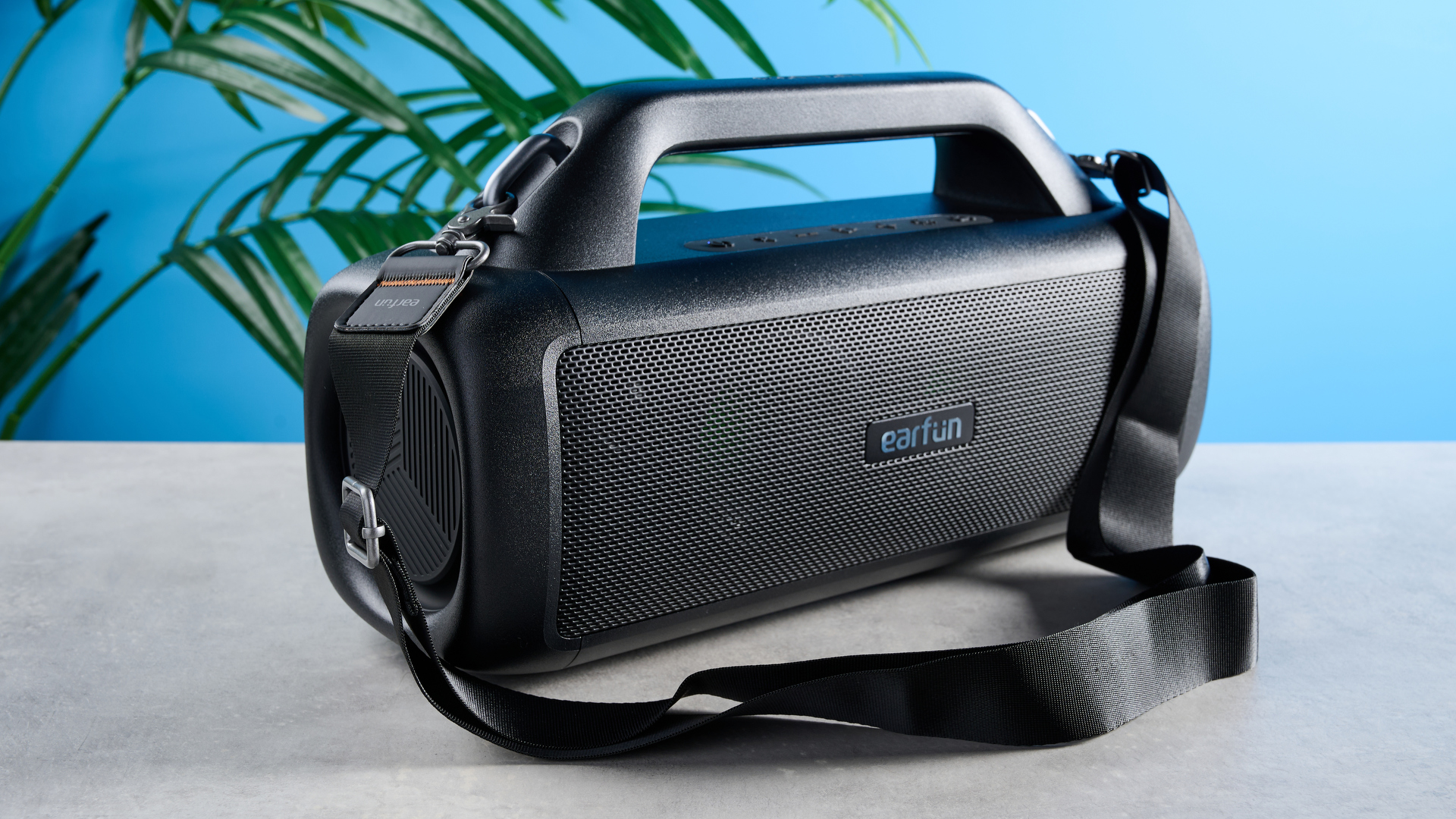 הרמקול הנייד EarFun UBOOM X boombox עם מופע אורות LED ולוגו earfun במרכז גריל הרמקול ושני סאב וופרים ורצועת נשיאה, מושלם למסיבות חוף בדירוג IP67