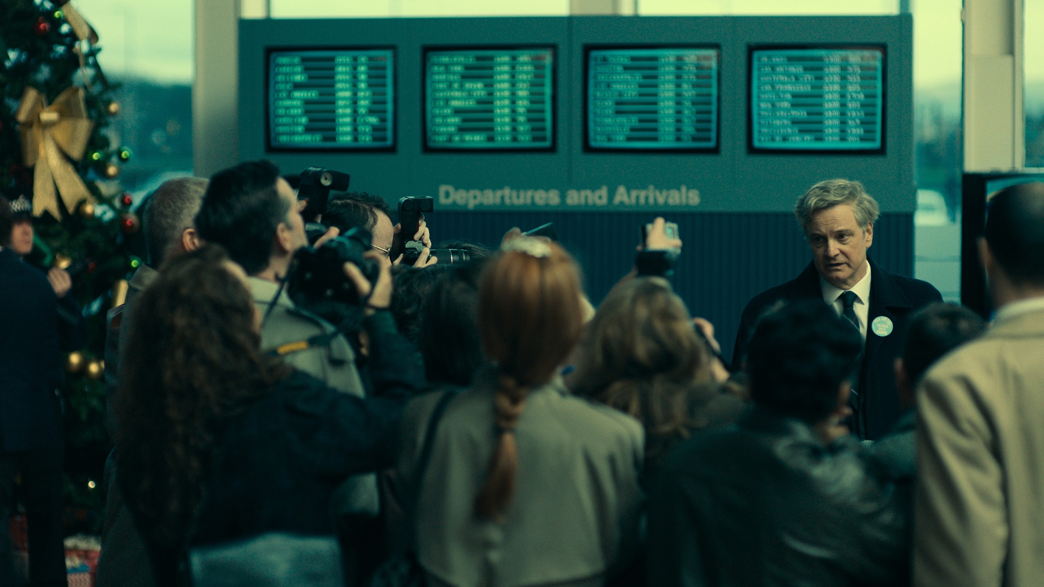 ג'ים סוויר (קולין פירת') מוקף באנשי עיתונות בשדה תעופה כפי שניתן לראות ב-Peacock and Sky's "לוקרבי: חיפוש אחר אמת"