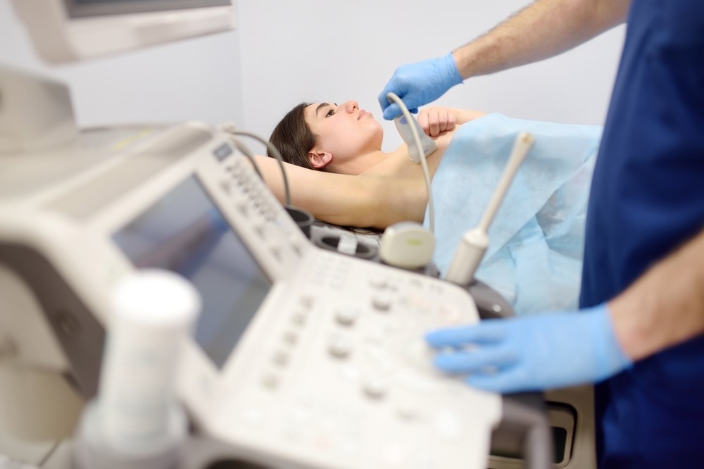 Mammologist doctor examines a woman breasts and lymph nodes using ultrasound.