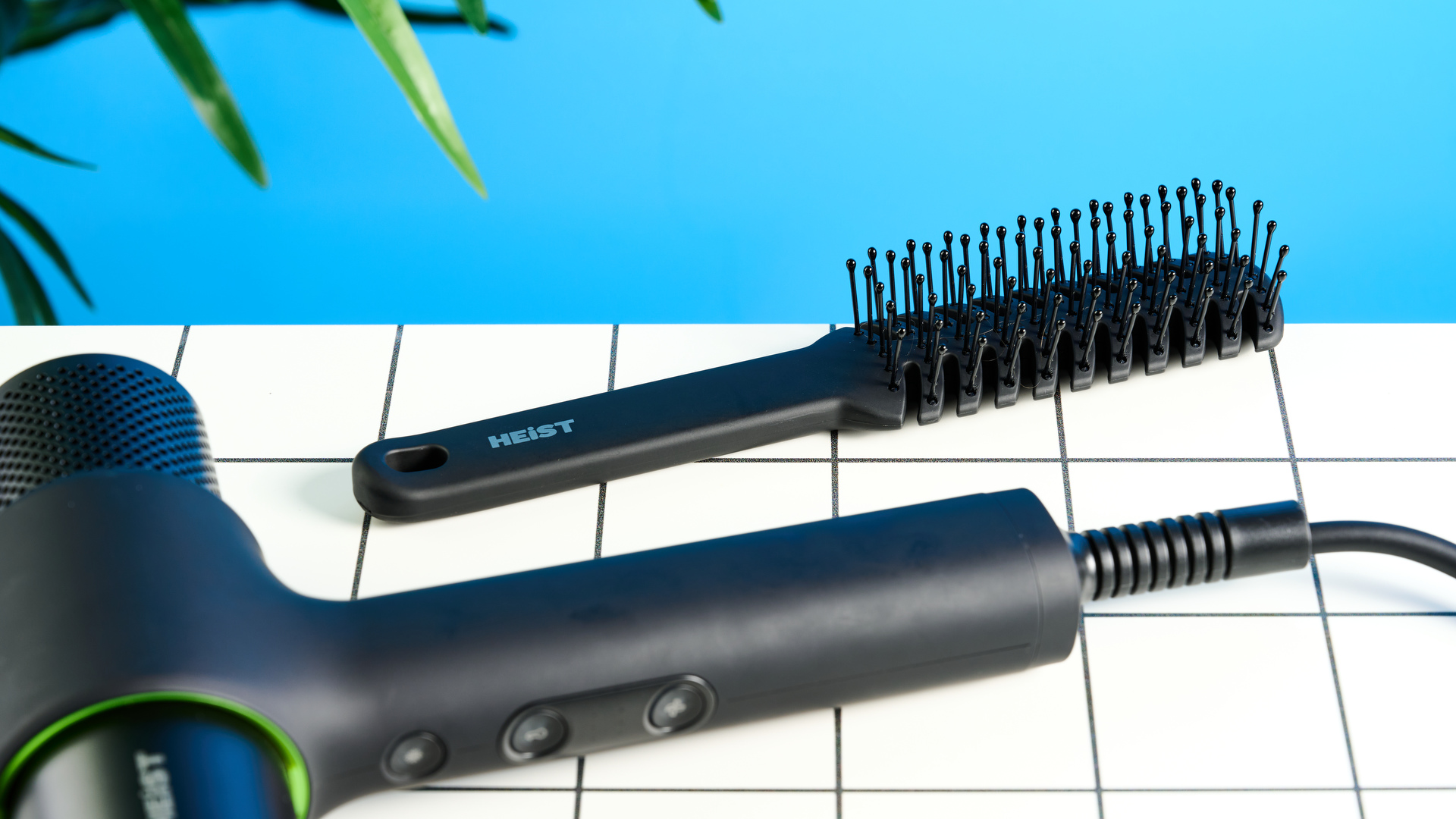 מייבש השיער של Heist 3.0 גברים בשחור עם טבעת ירוקה בהירה ומצורף מגנטי שצולם על רקע כחול