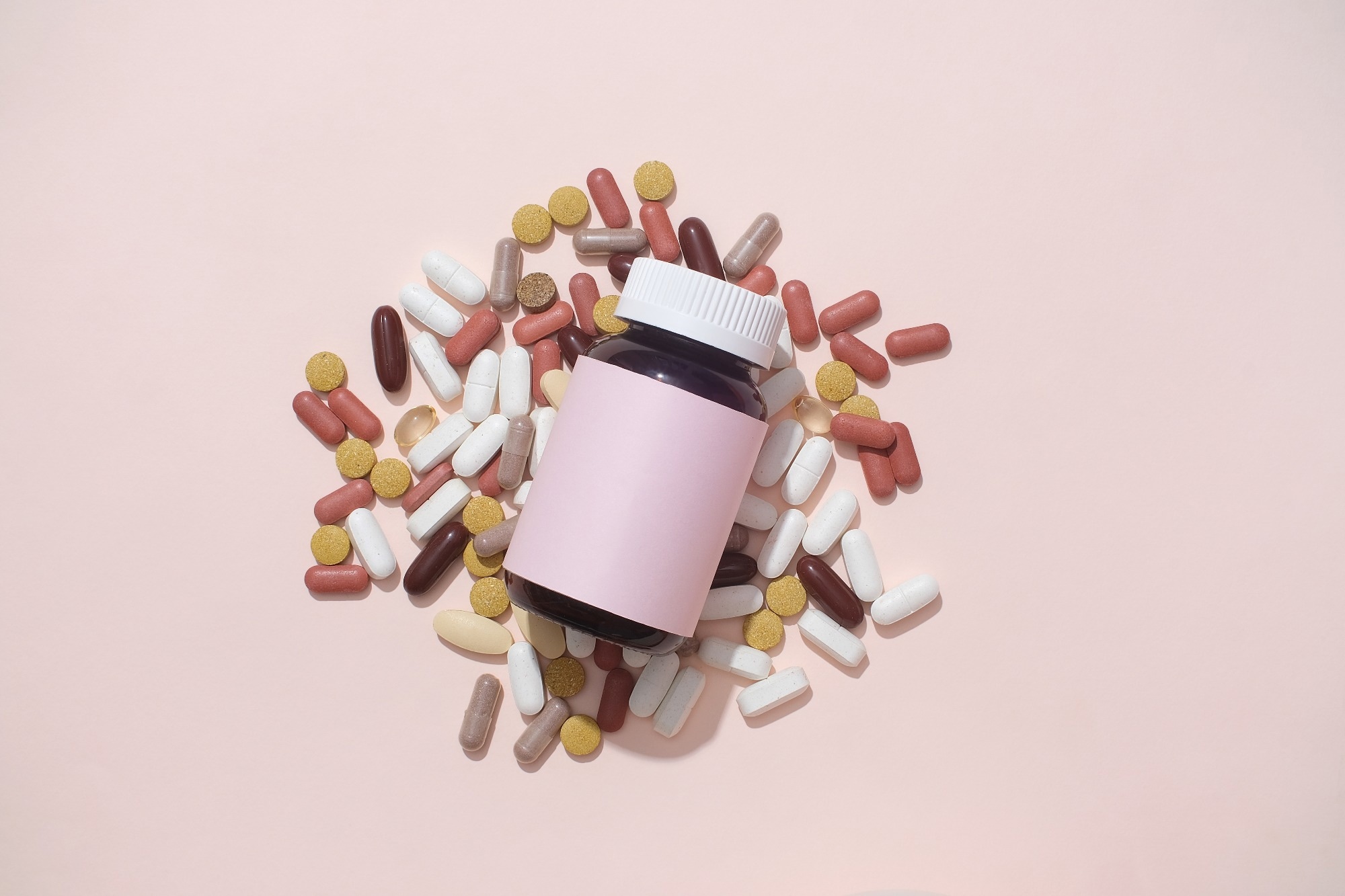 Pills of different colors and shapes are mixed.