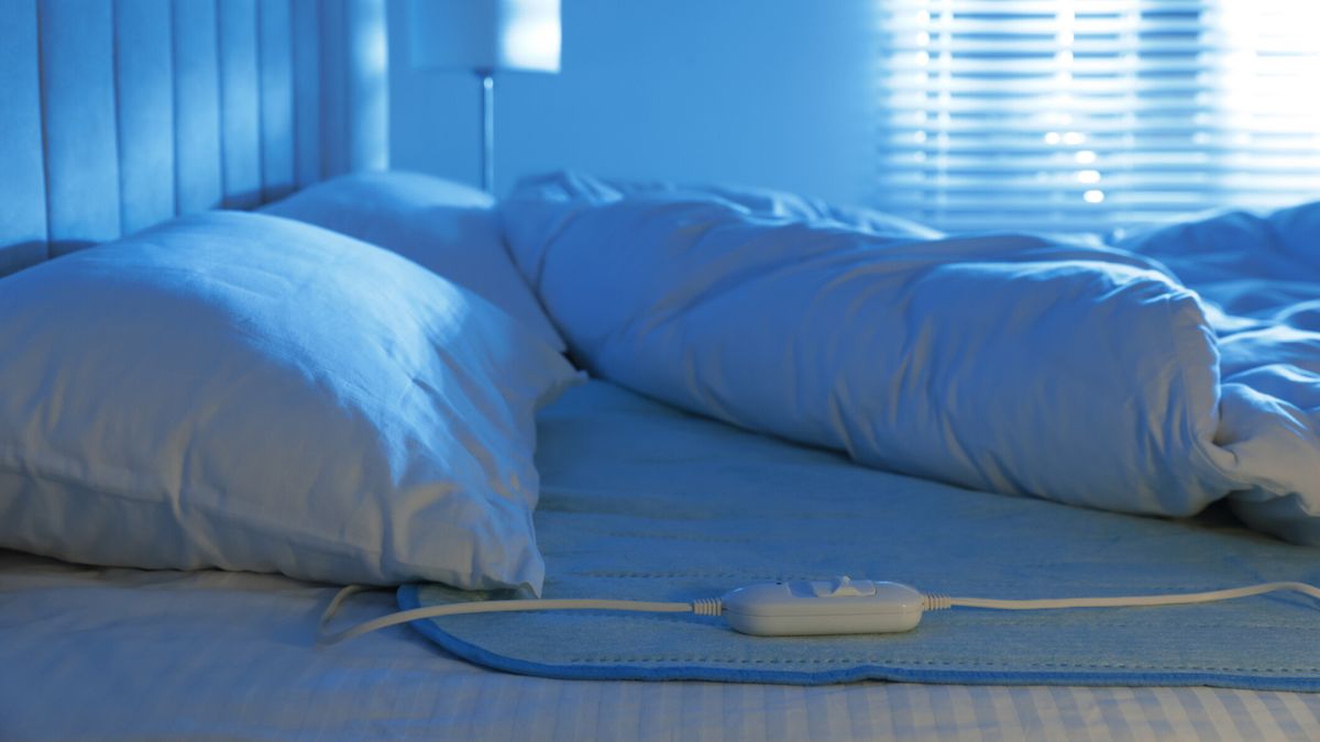An electric blanket on bed below the duvet