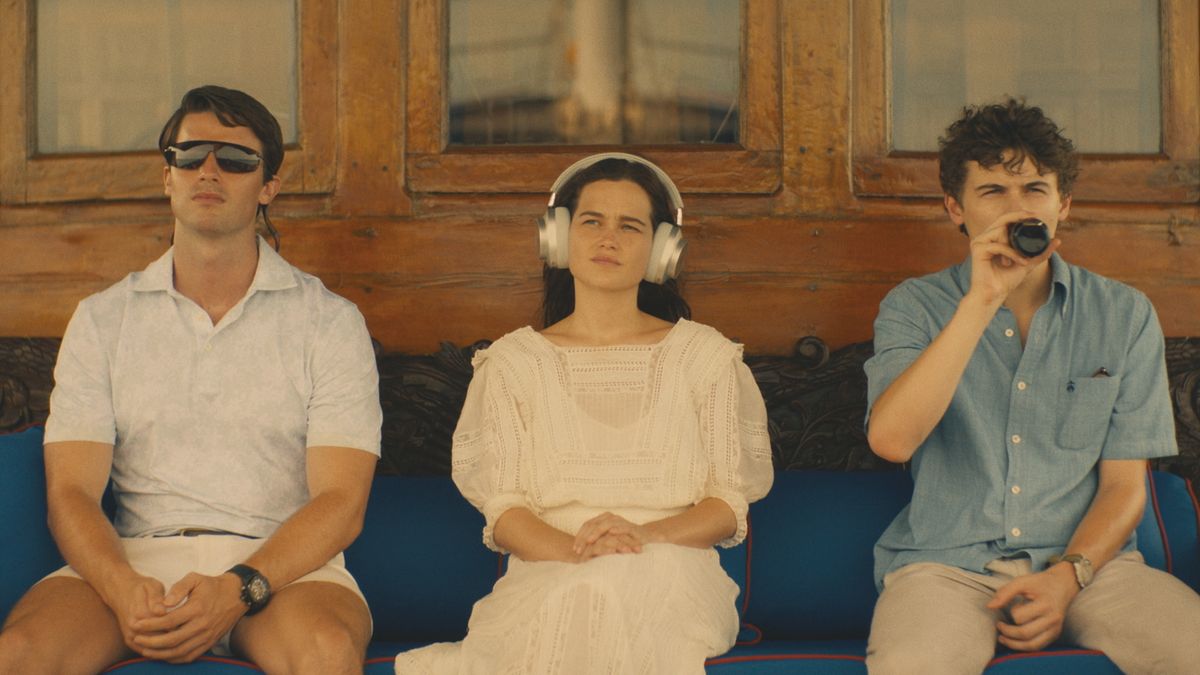 L-R: Patrick Schwarzenegger, Sarah Catherine Hook and Sam Nivola sitting on a bench in HBO's "The White Lotus" season 3