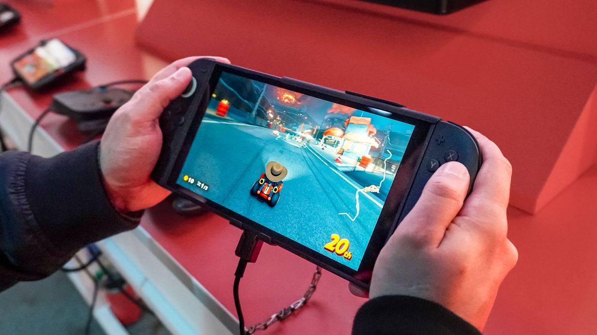A person holding a Nintendo Switch 2 playing Mario Kart World