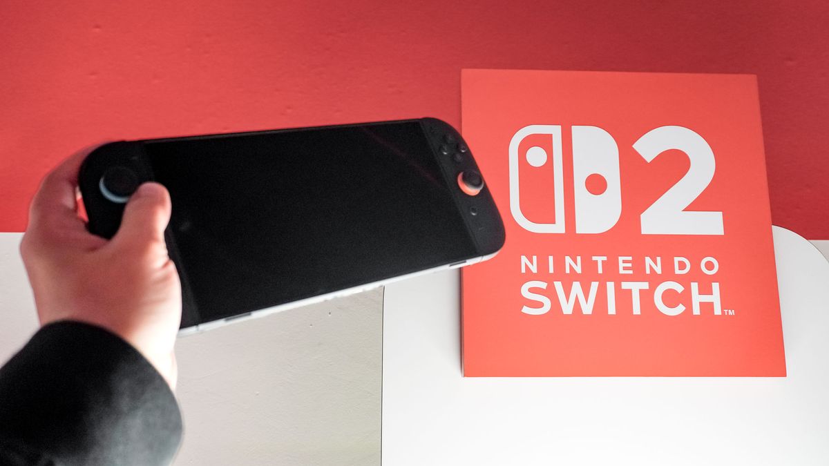 A Nintendo Switch 2 console in hand next to the Nintendo Switch 2 logo