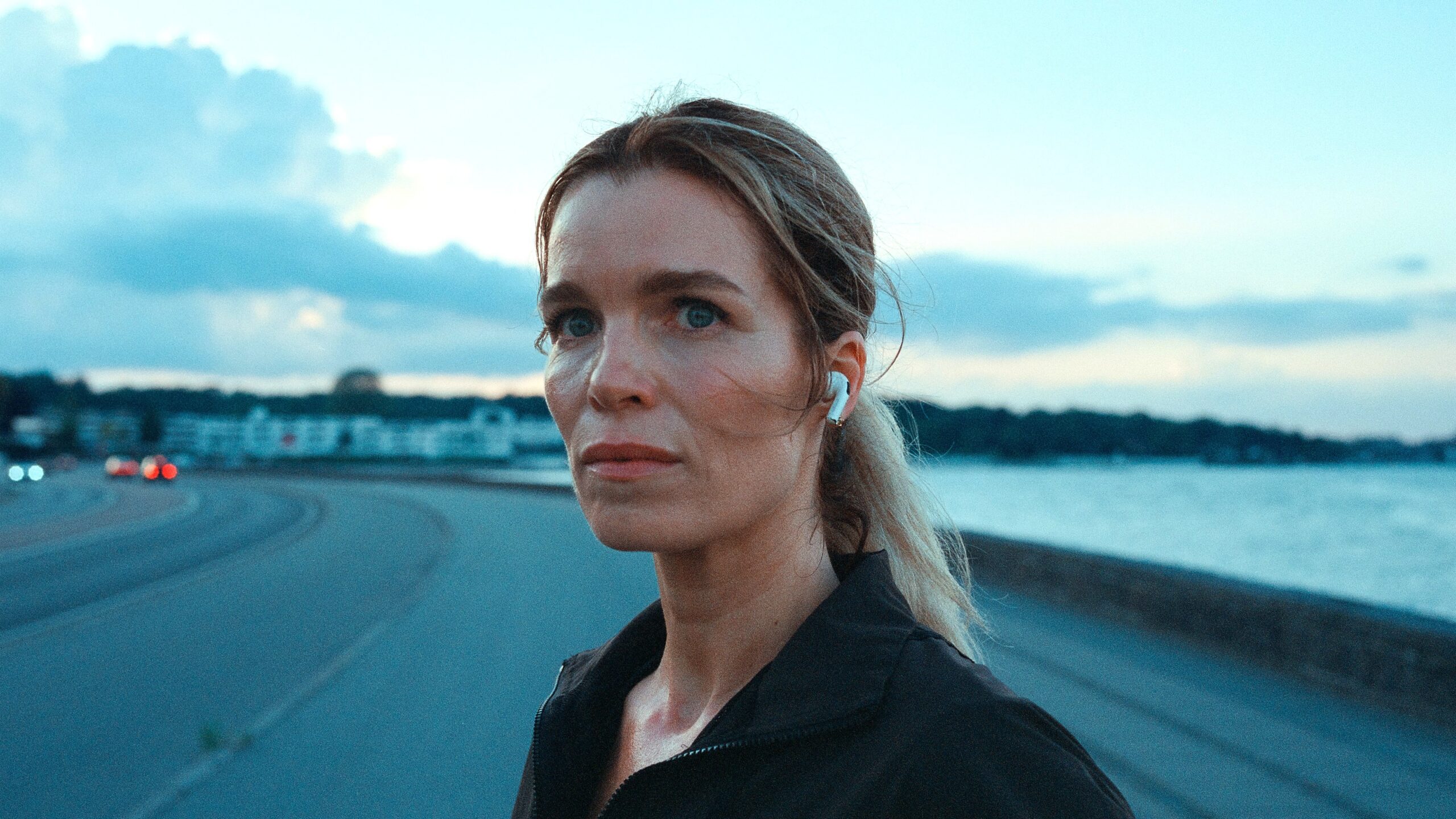 Cecile Vinter-Jensen (Marie Bach Hansen) stands on a sidewalk in Netflix's "Secrets We Keep"