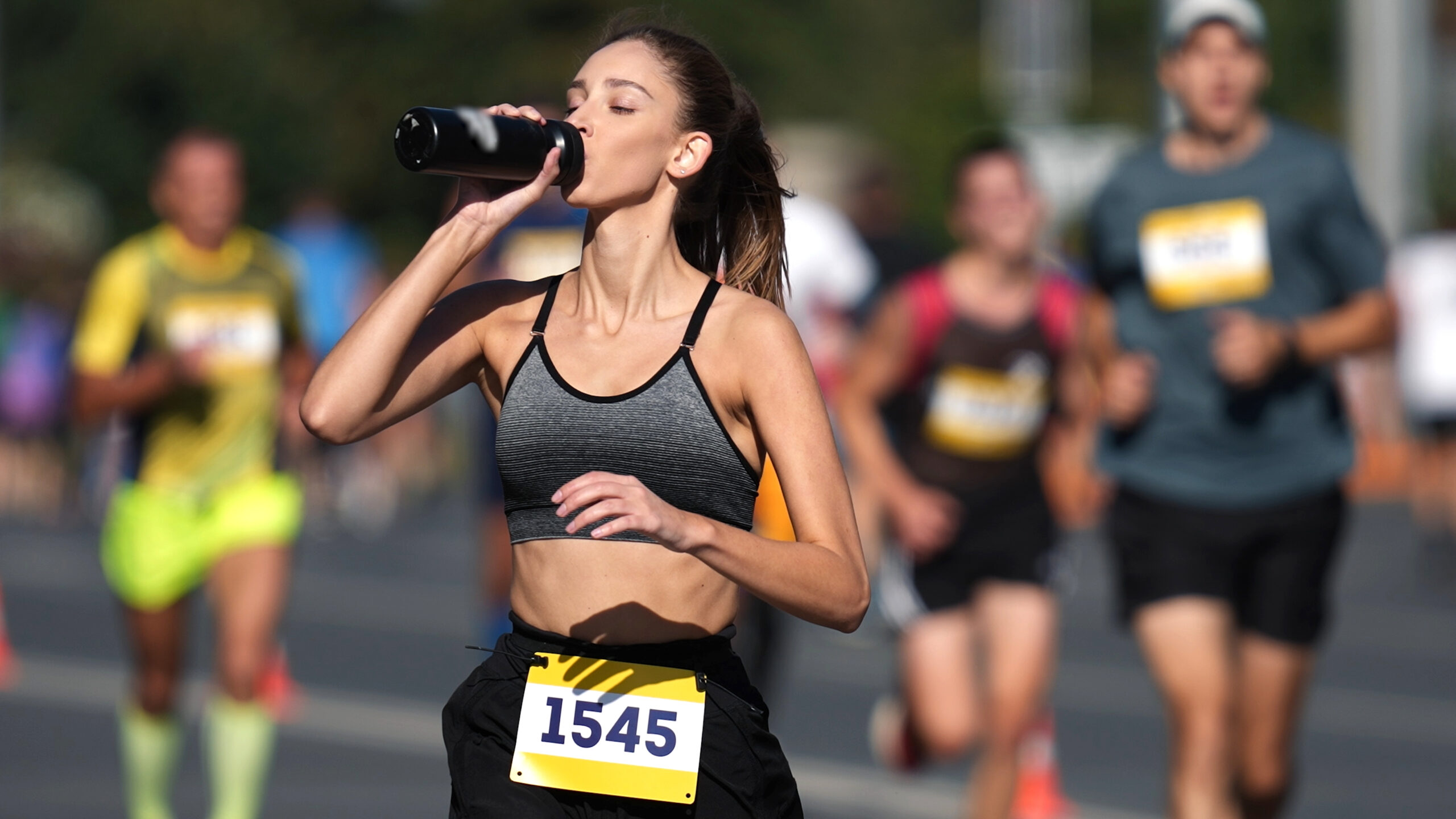 a female runner drinking water during a race