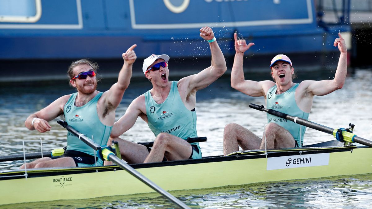 (L-R) Cambridge rowers Seb Benzecry, Ben Dyer and Theo Weinberger celebrate their win over Oxford at the finish of the 166th annual men's boat race between Oxford University and Cambridge University on the River Great Ouse in Ely, eastern England
