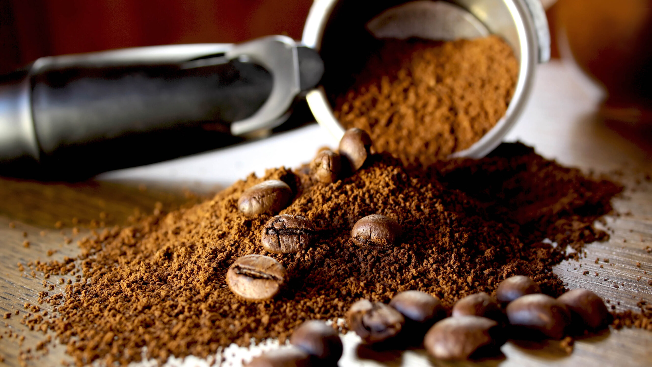 Coffee grounds and beans spilled over from a portafilter