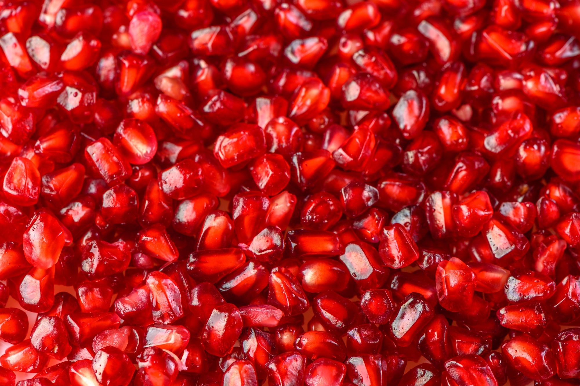 Delicious red ripe juicy pomegranate seed background texture.