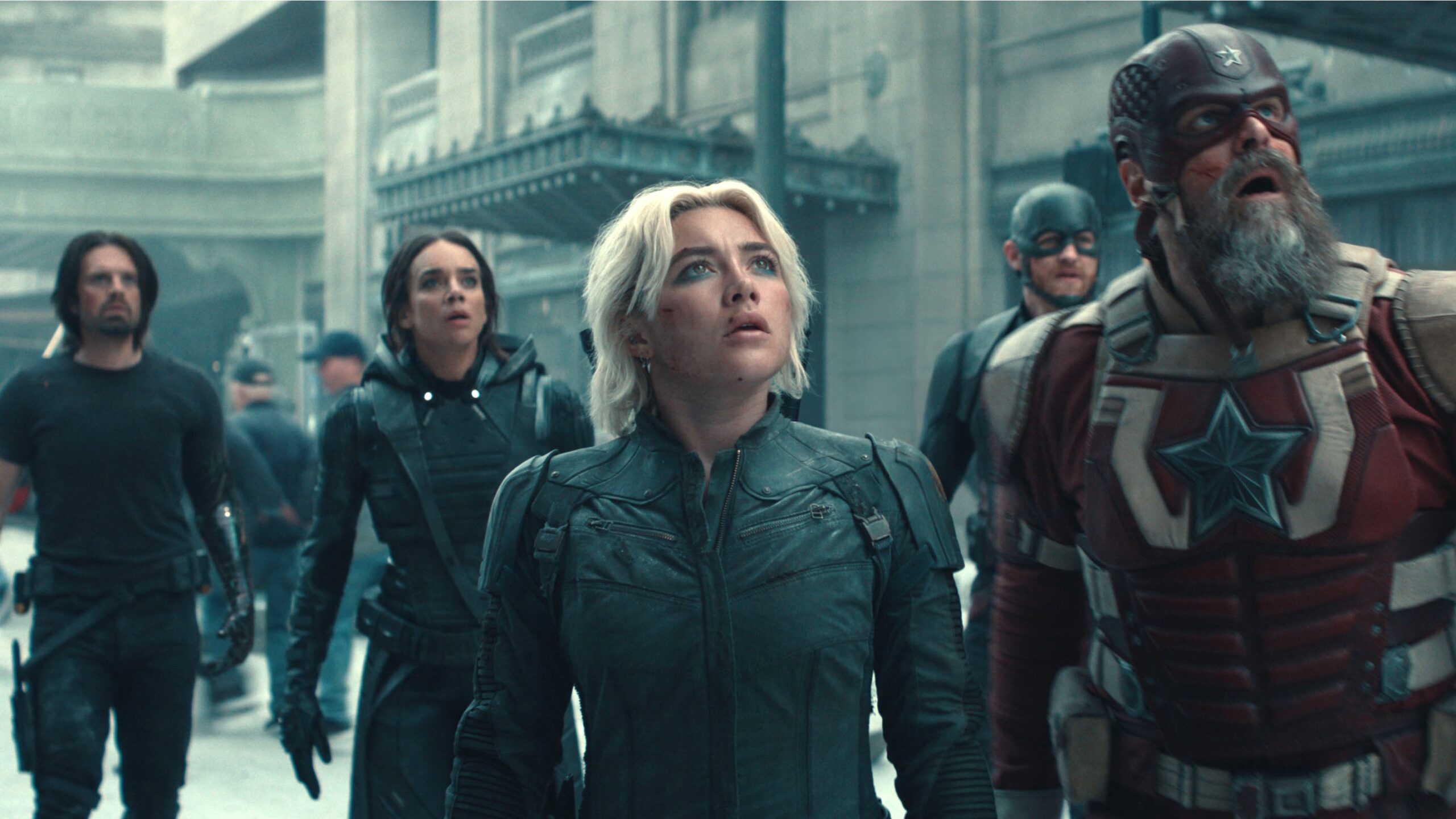 L-R: Bucky Barnes (Sebastian Stan), Ghost (Hannah John-Kamen), Yelena Belova (Florence Pugh), John Walker (Wyatt Russell) and Red Guardian (David Harbour) stand in a street looking shocked in a scene from Marvel Studios