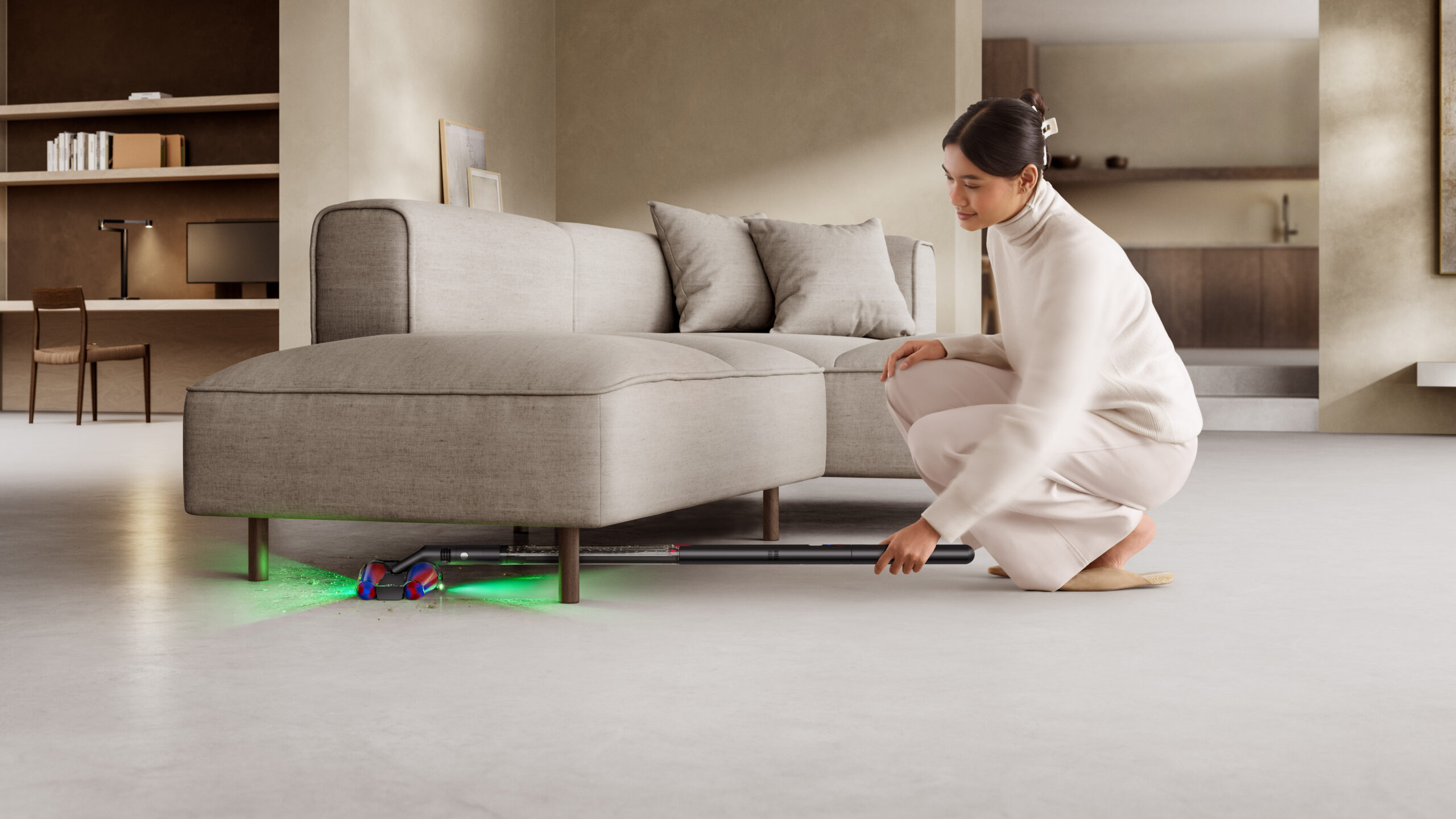 Woman using the Dyson PencilVac to clean under sofa