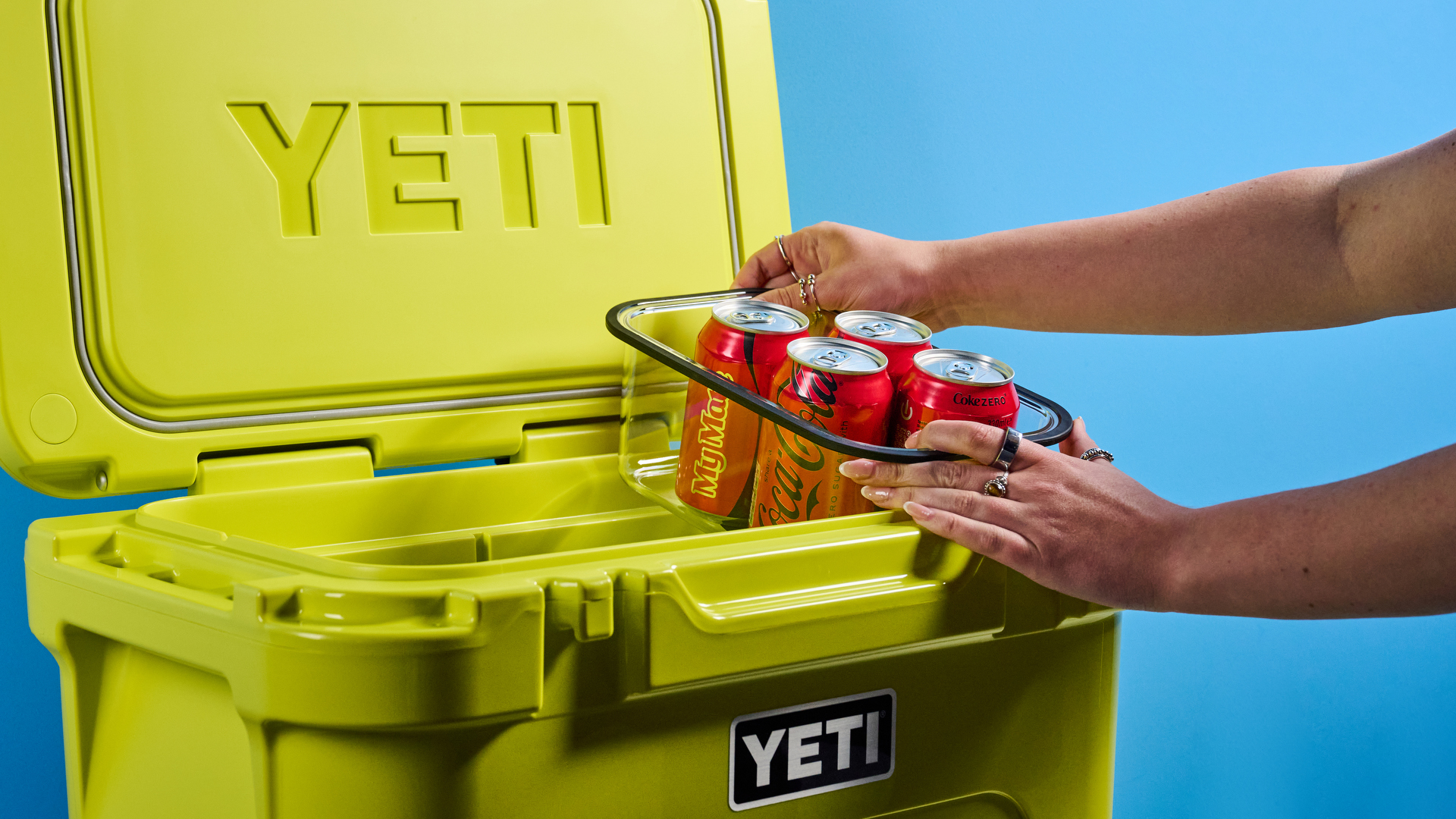 מקרר ה- Yeti Roader בצהוב ניאון עם גלגלים, צירים קרובים רכים, ידית נשלפת ו 32 יכולת ליטר