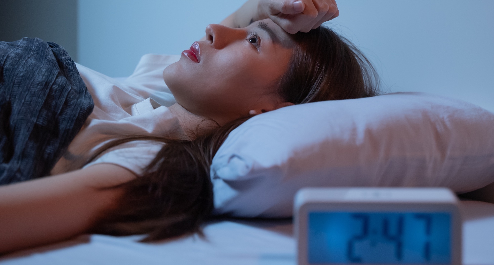 A woman having trouble falling asleep in bed
