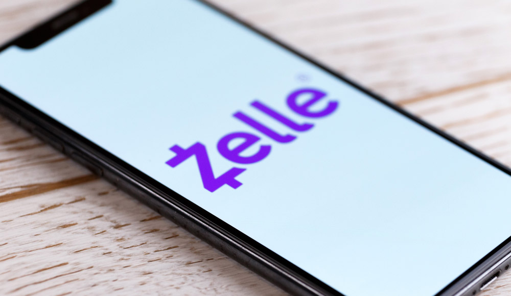 The Zelle logo in purple against a white background displayed on a smartphone screen.