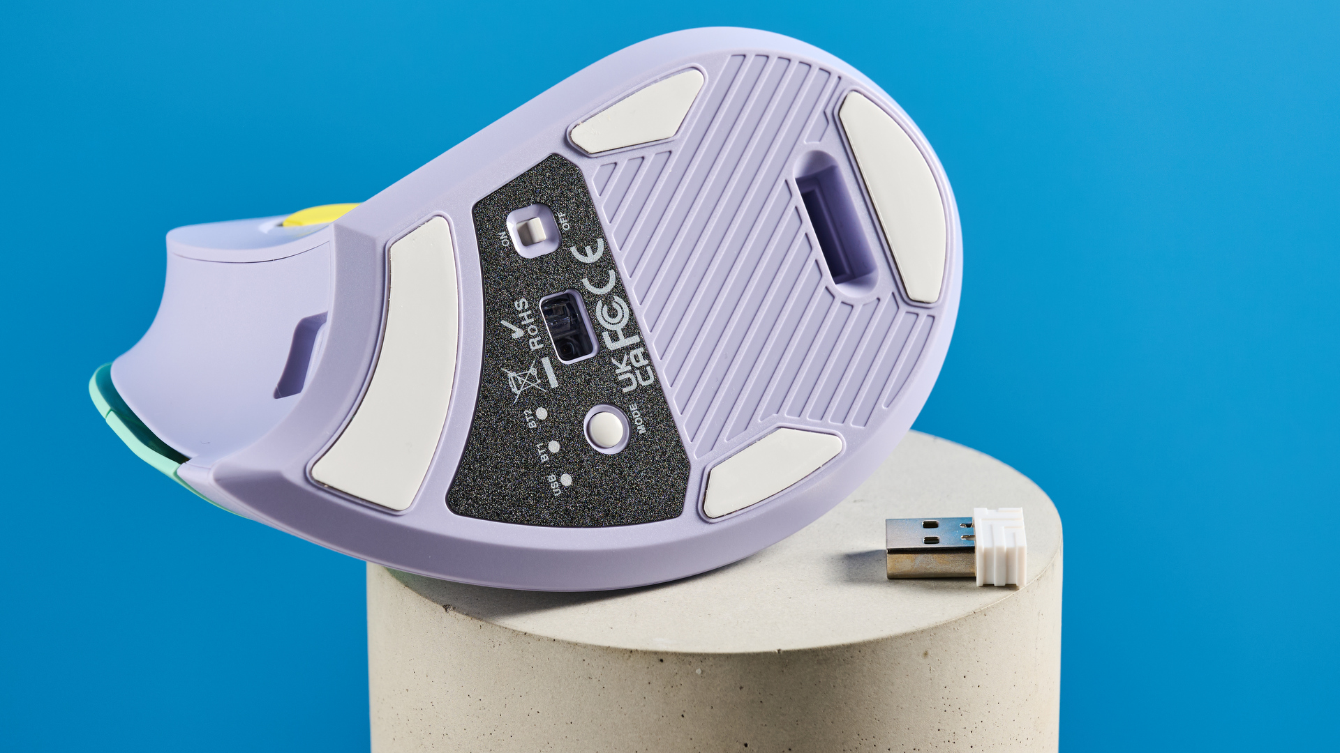 Seenda Mou-302 עכבר אלחוטי אנכי במינג ובצבע צבעוני סגול עם מבטאים צהובים שצולמו על רקע כחול.