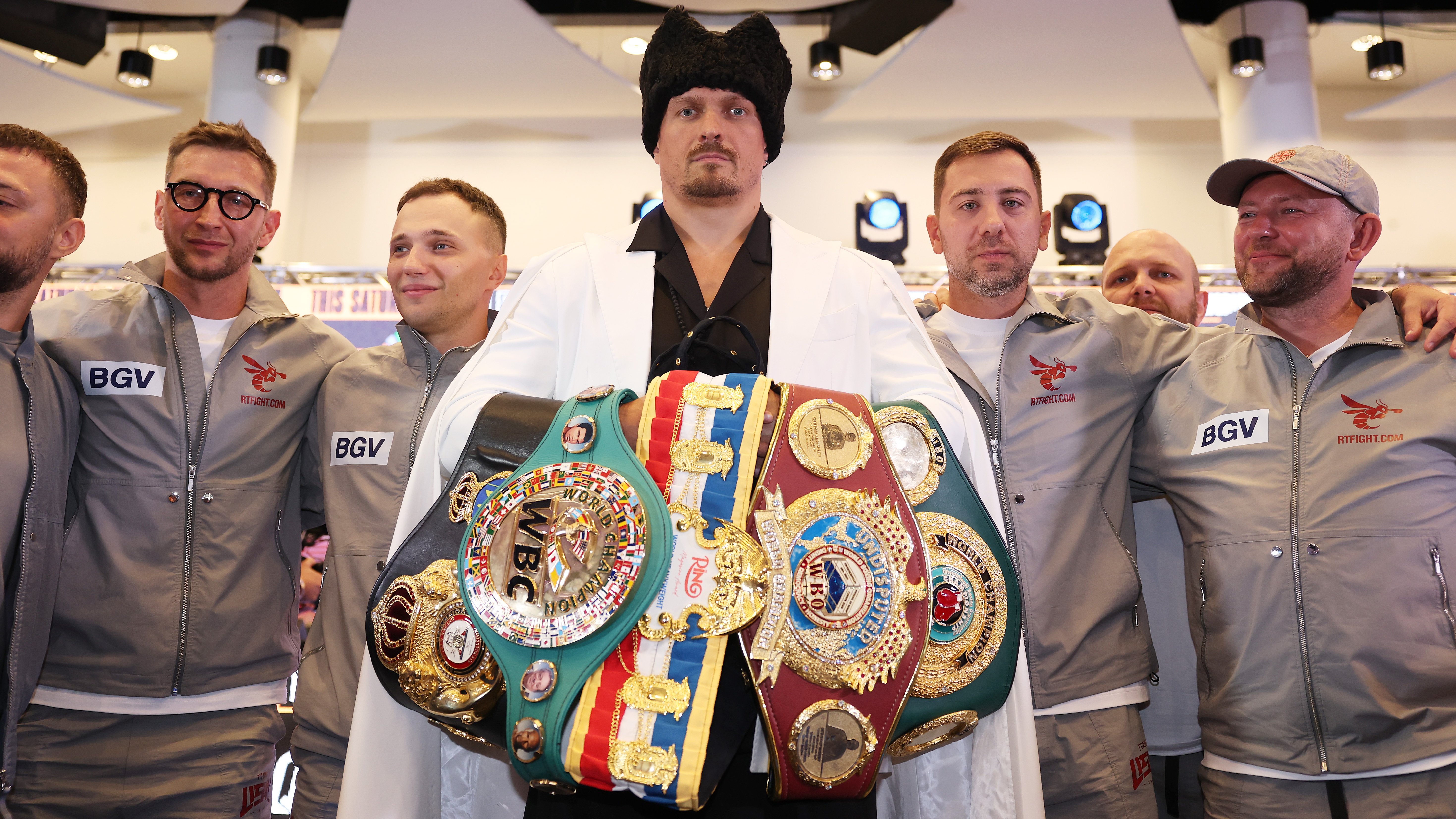 Oleksandr Usyk מציב תמונה עם חגורותיו במהלך מסיבת העיתונאים 'הבלתי מעורערת' באצטדיון וומבלי