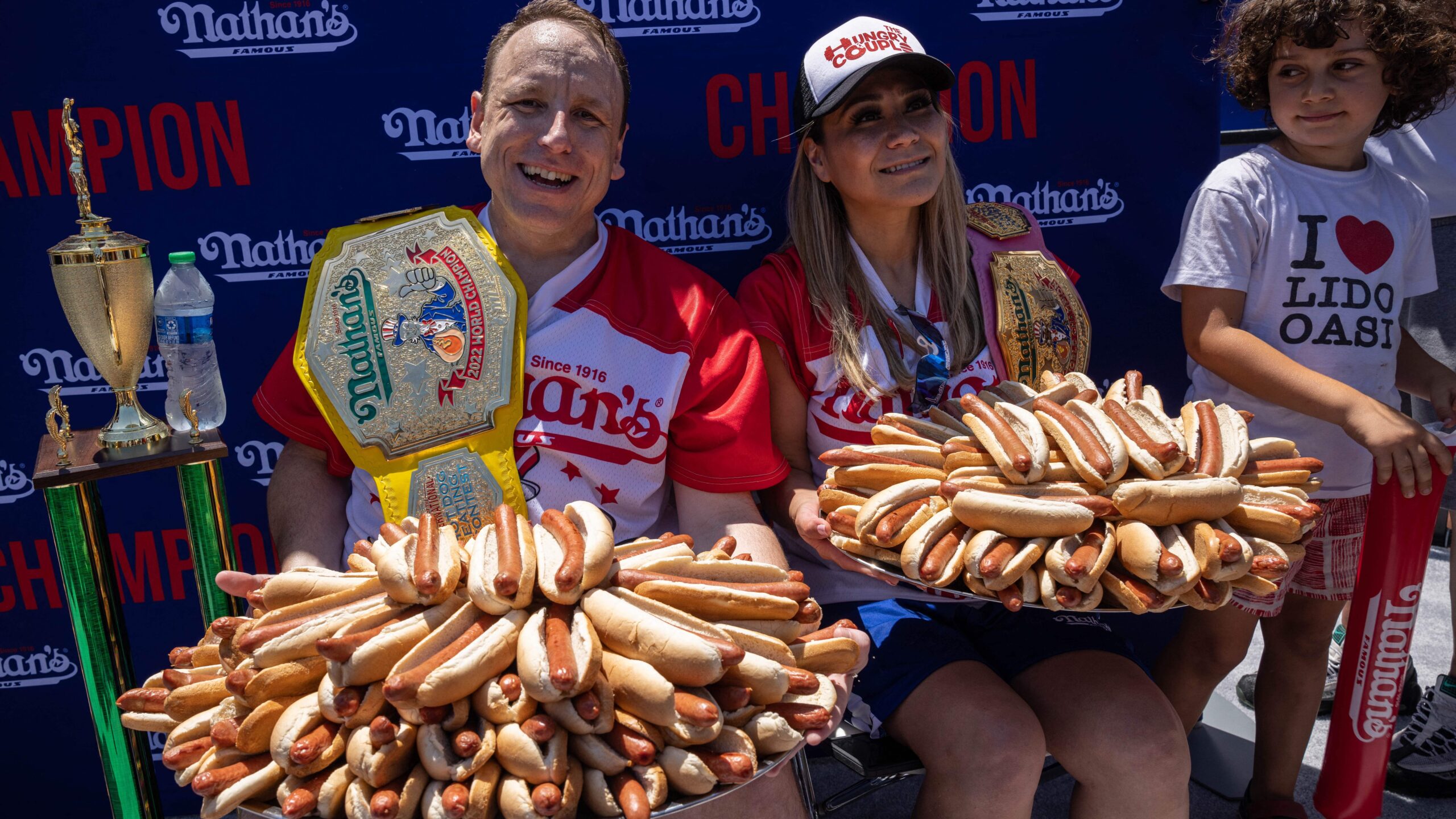 Joey Chestnut (L) and Miki Sudo (R) hold 63 and 40 hot dogs respectively after winning the Nathan's Famous 4th of July 2022 hot dog eating contest on Coney Island on July 4, 2022 in New York.