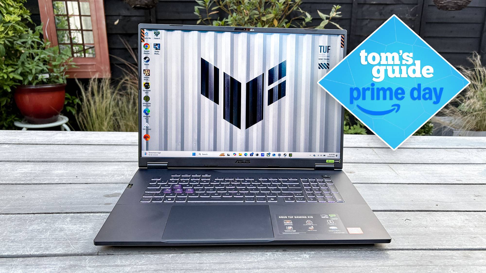 Asus tuf Gaming A18 על השולחן בחוץ עם התג של טום מדריך ראש הממשלה