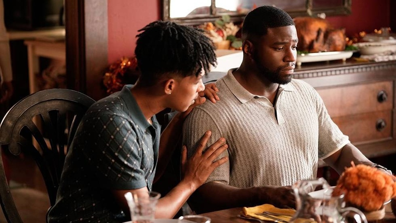 From left to right: Redd (Caleb Eberhardt) comforts Demascus (Okieriete Onaodowan) as they sit down at the dinning table for Thanksgiving dinner in a still from Tubi Original series "Demascus".