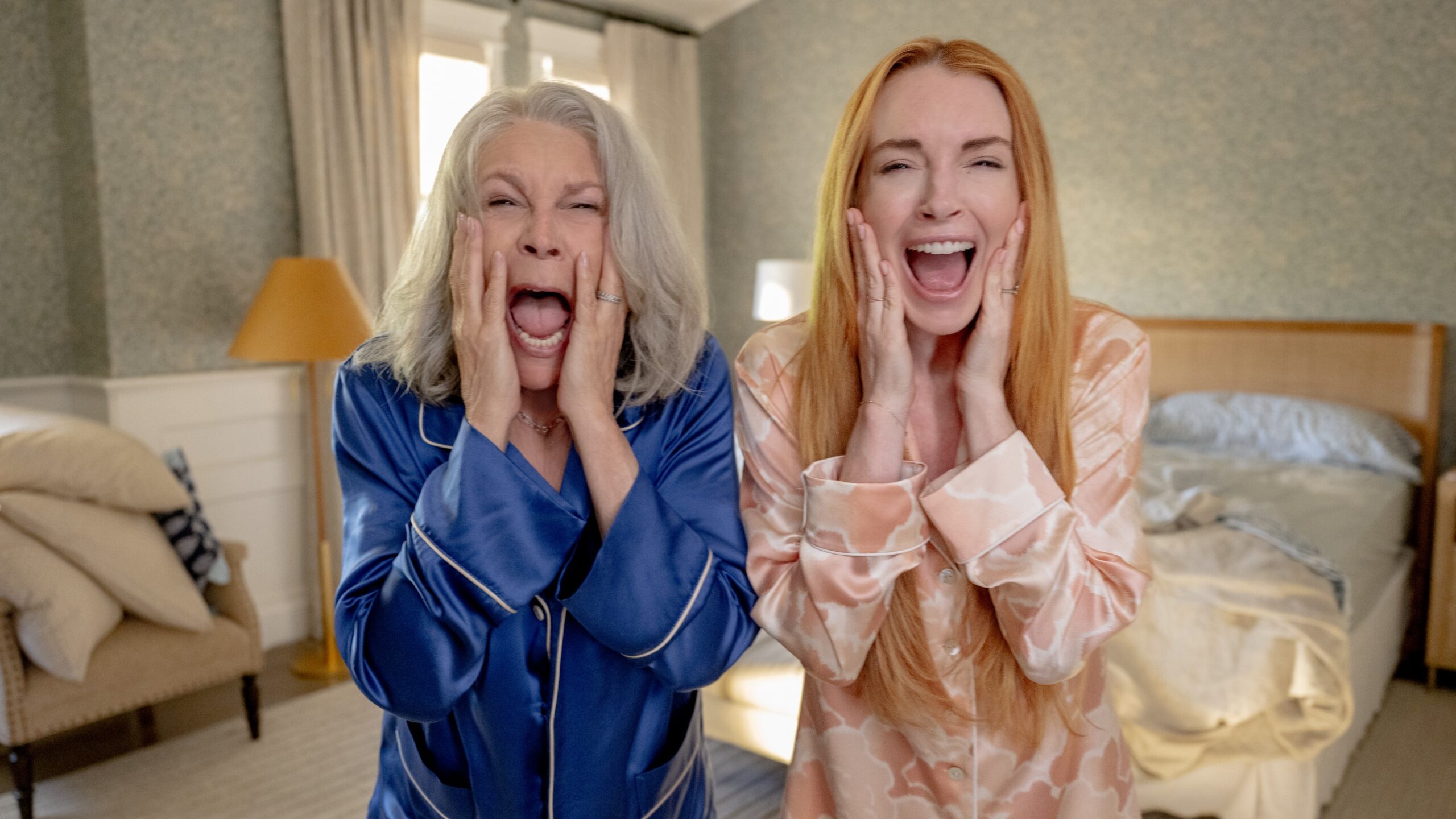 L-R: Tess (Jamie Lee Curtis) and Anna (Linsday Lohan) standing side-by-side and screaming in their in PJs in a scene from "Freakier Friday"