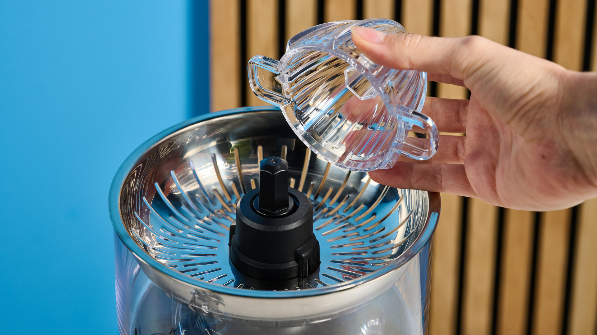 KitchenAid Go מסחטת הדרים חסרת אלחוט בשחור מט שצולם מול רקע כחול.