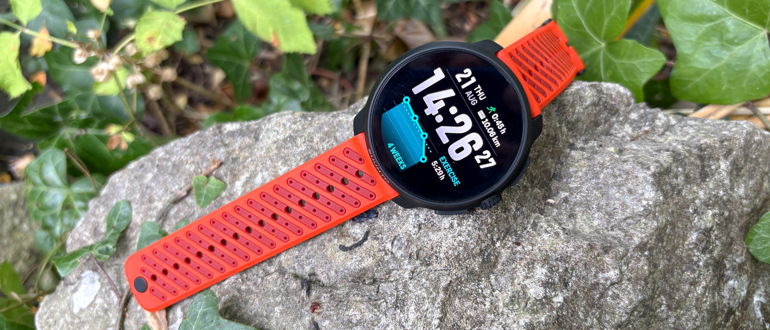 Suunto Race 2 with orange strap on a rock outside
