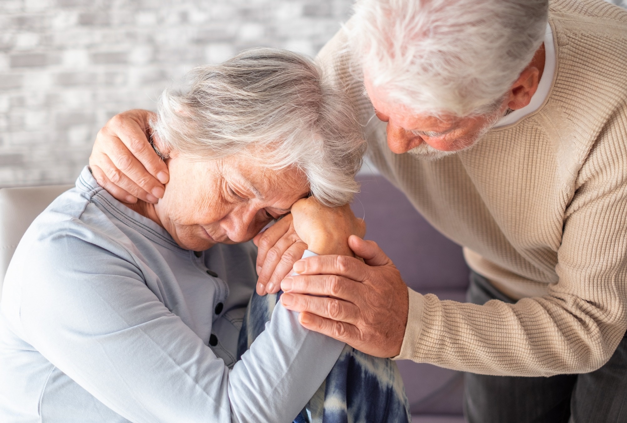 Senior man comforting his depressed illness wife