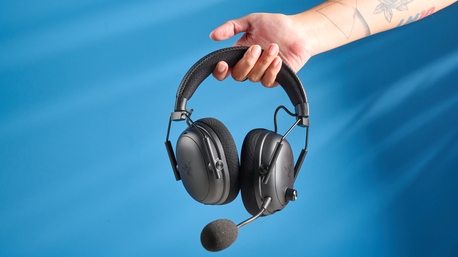 אדם המחזיק אוזניות משחקי Razer Blackshark V3 Pro