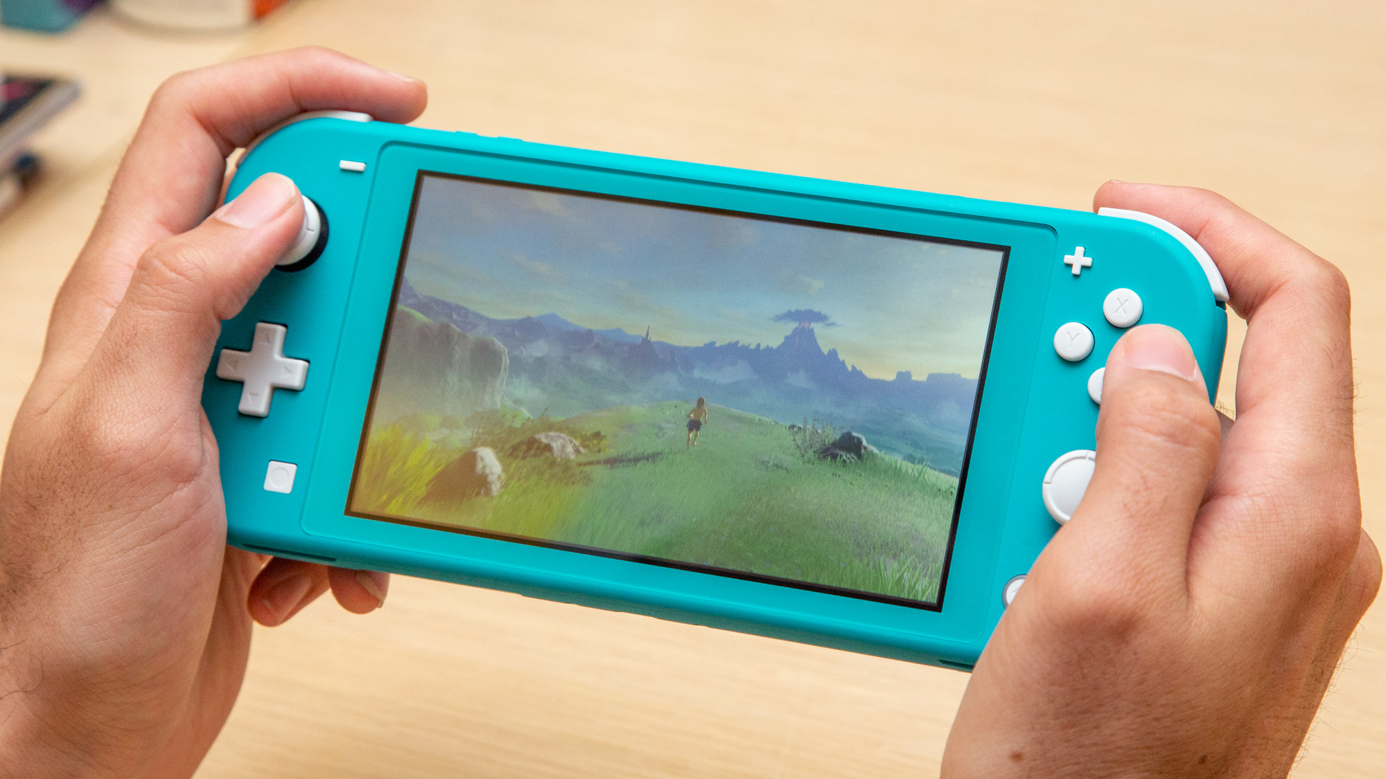 Nintendo Switch Lite ביד ומנגן נשימה של הטבע