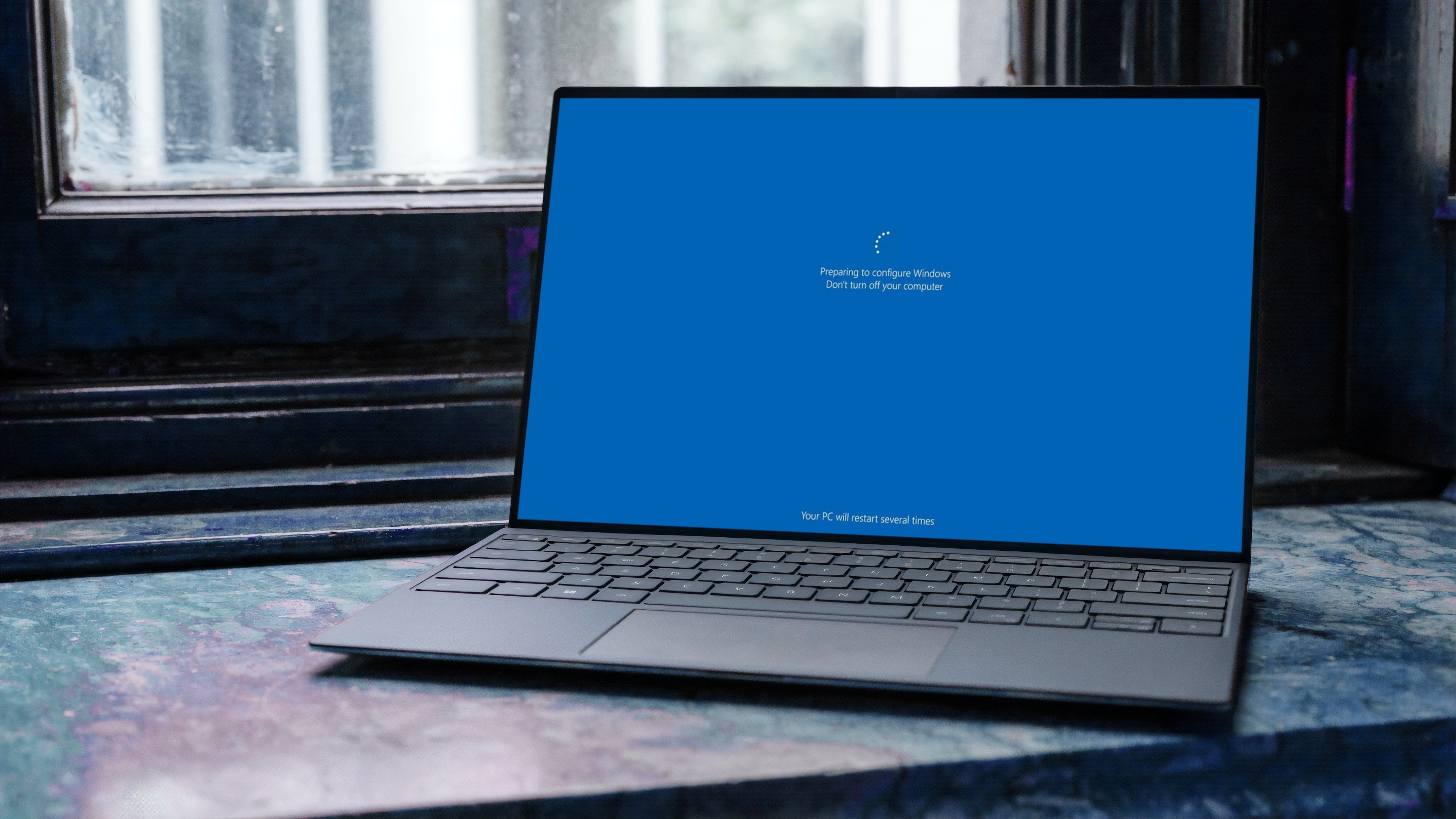 מחשב נייד על אדן החלון באמצע עדכון Windows