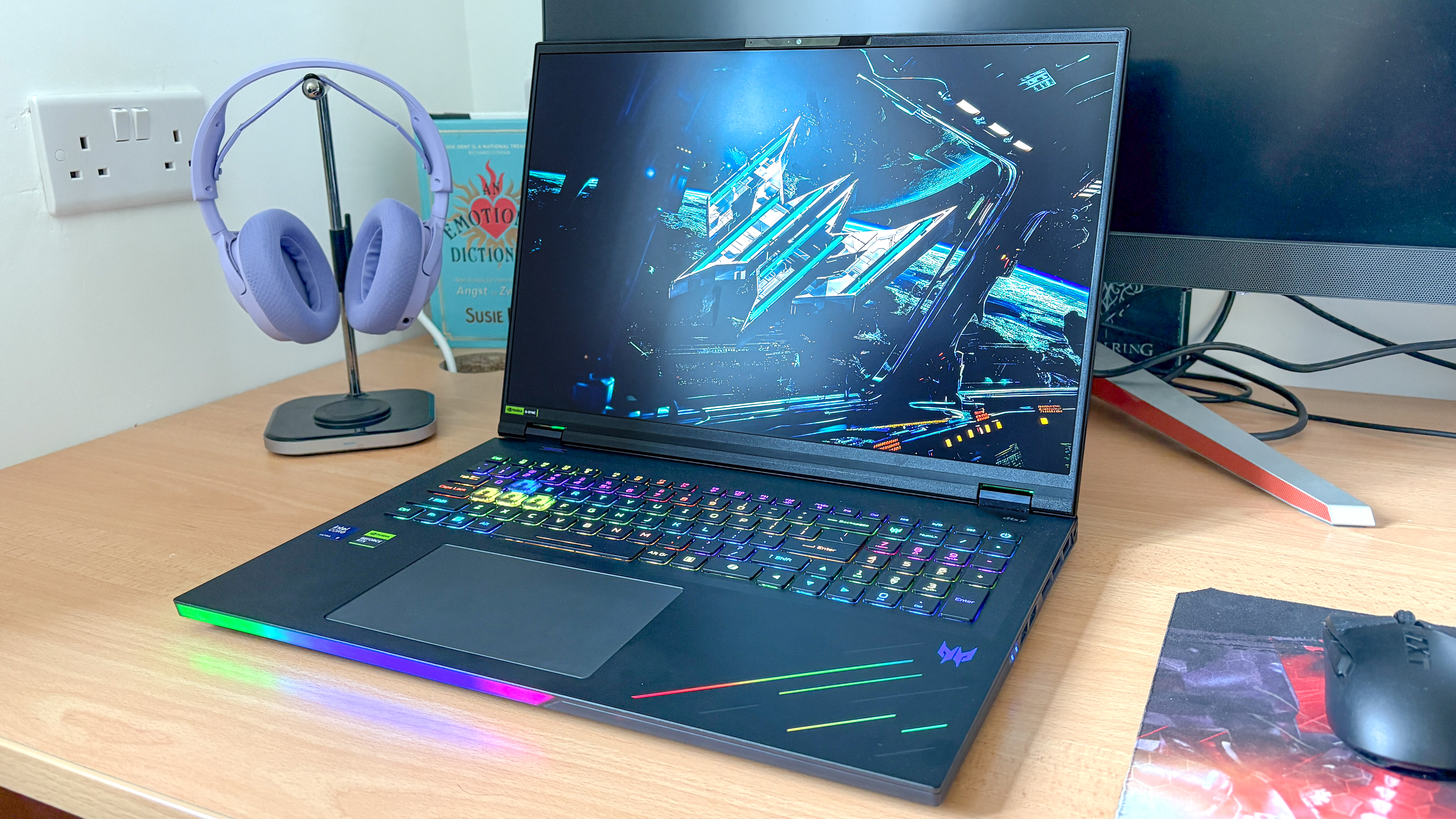 Acer Predator Helios 18 AI על שולחן העבודה ליד אוזניות המסיירות מעמד ועכבר