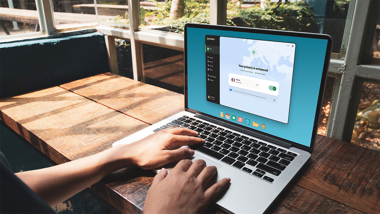 אדם עובד על מחשב נייד המציג תוכנת VPN של נורטון על המסך.