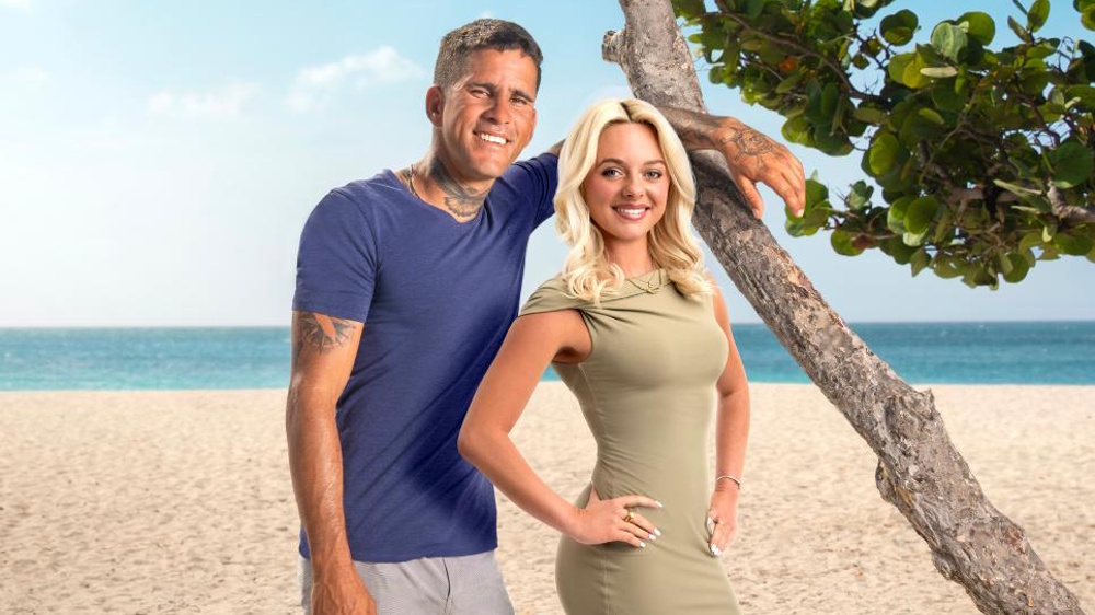Johny &amp; Chloe posing on a beach in a promotional image for ’90 Day Fiance: The Other Way' season 7.
