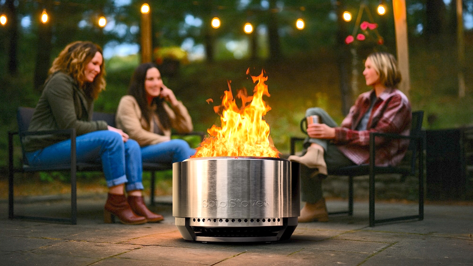 women sitting around Solo Stove Summit 24
