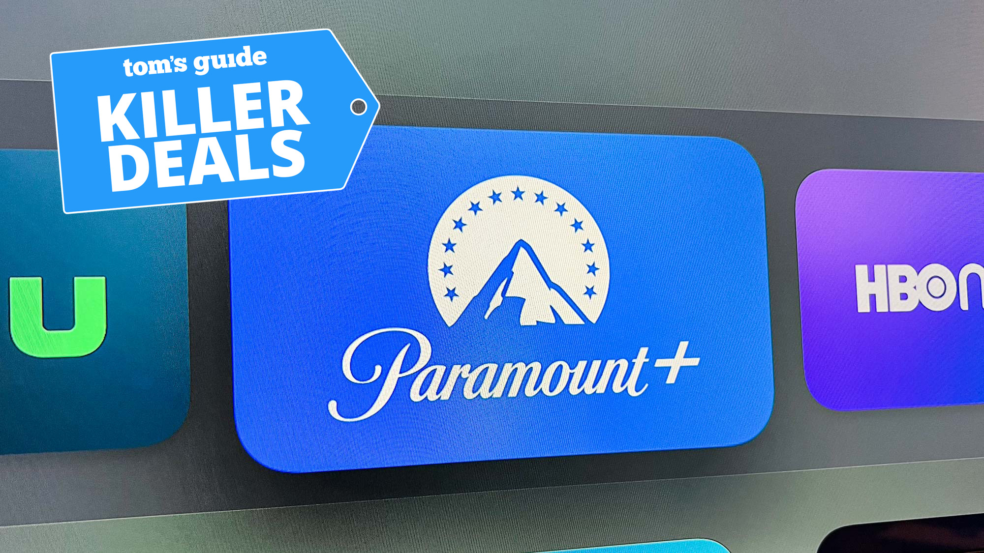 כפתור האפליקציות Paramount Plus ב- Apple TVOS, בין כפתורי Hulu ו- HBO Max, עם תג מדריך של TOMTH;