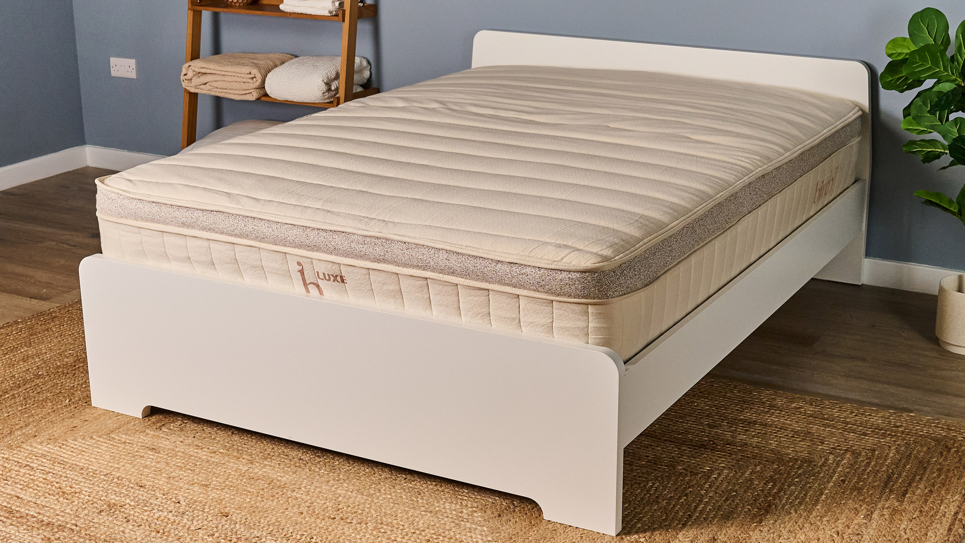 המזרן הטבעי Luxe Luxe על מסגרת מיטה לבנה בחדר שינה פתוח