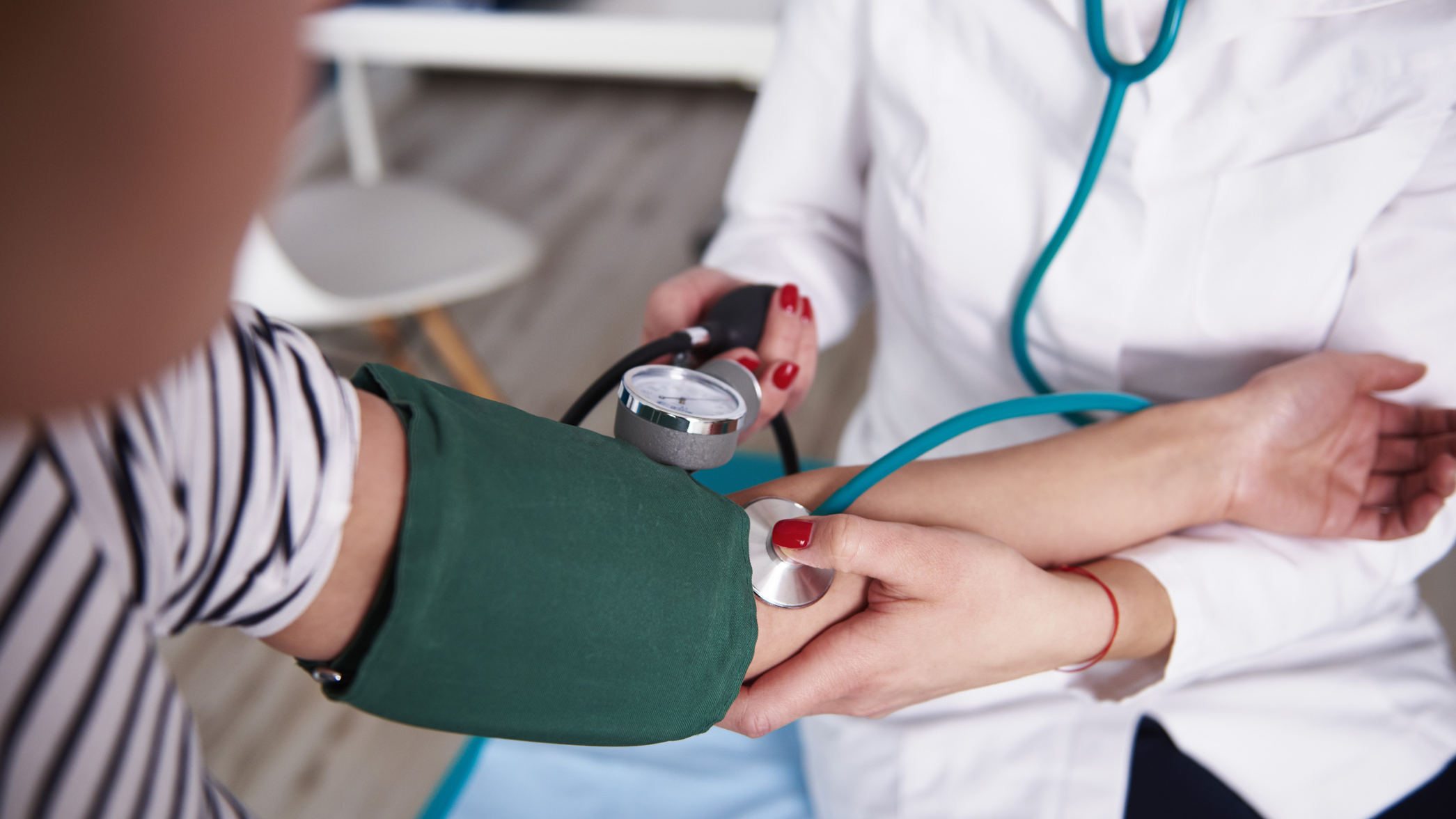 Doctor taking a patient's blood pressure at an appointment