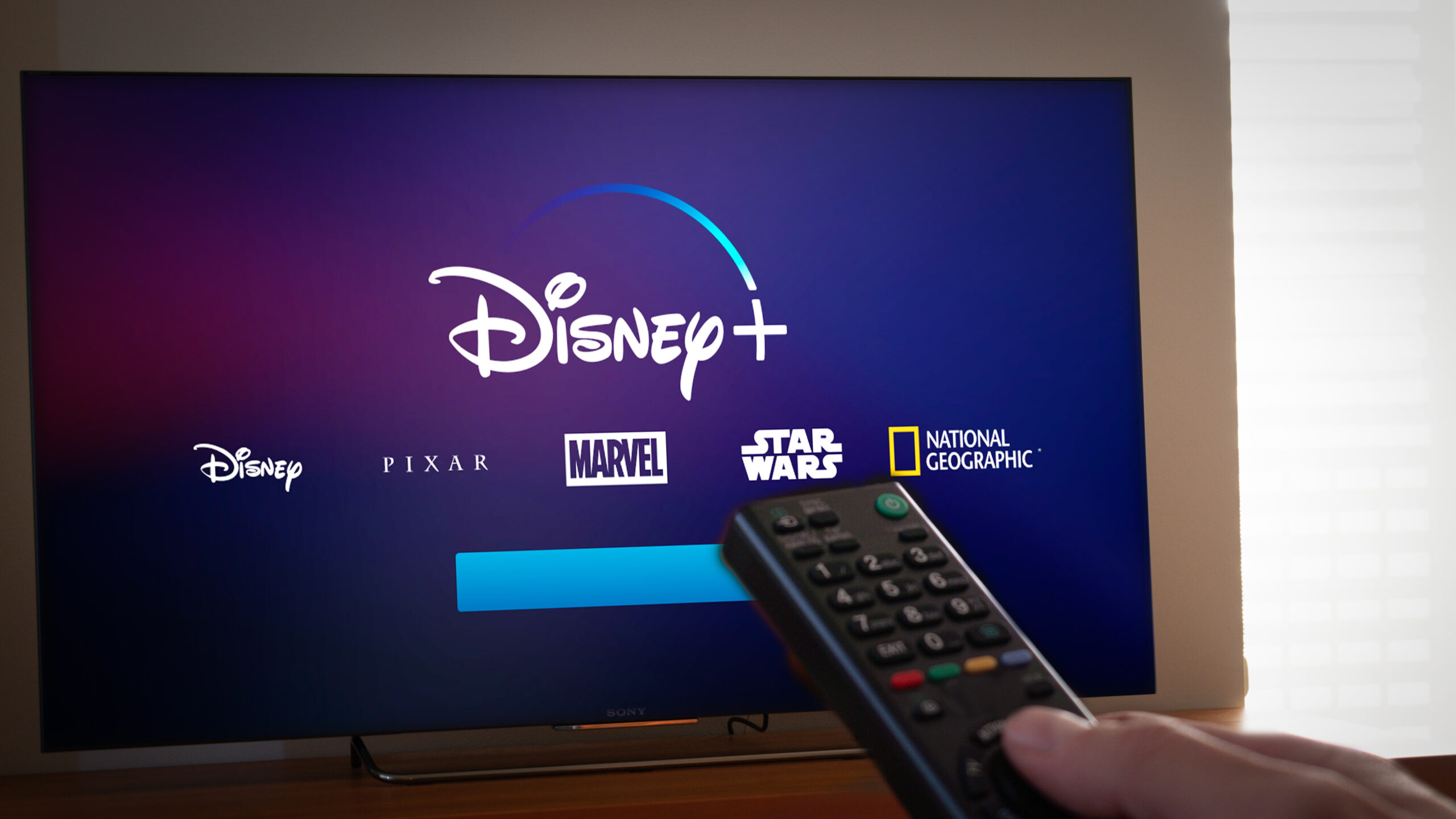 Barcelona, Spain. Jan 2019: Man holds a remote control With the new Disney+ screen on TV. Disney+ is an online video streaming subscription service, set to launch in the US in September.Illustrative - Image