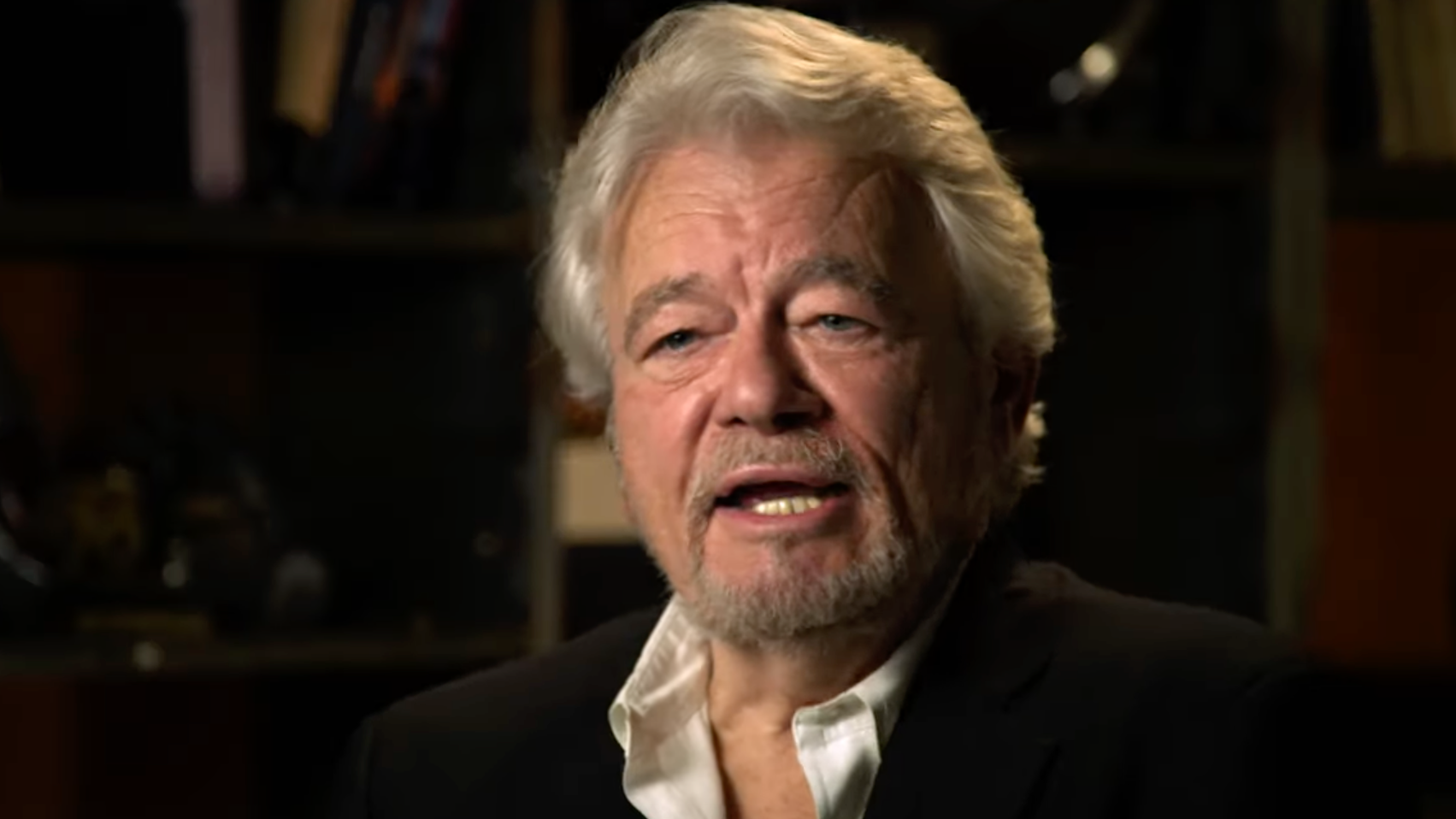 Reporter George Knapp, with silver hair, in white shirt talking on Netflix series "Investigation Alien" 2024