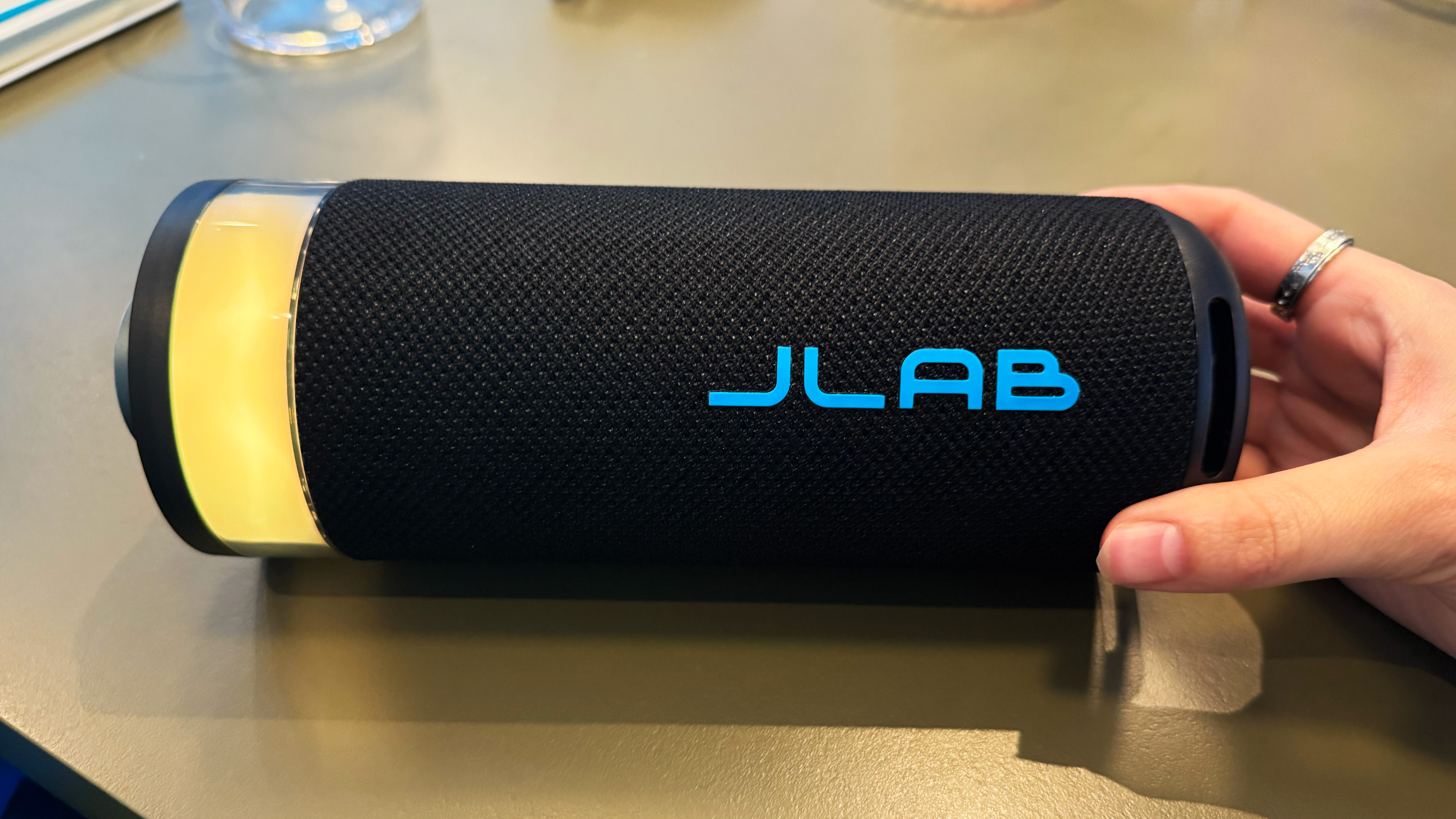 דובר המסיבה של JLAB GO עם LED צהוב ויד של המחבר בתמונה המחזיקה את הדובר