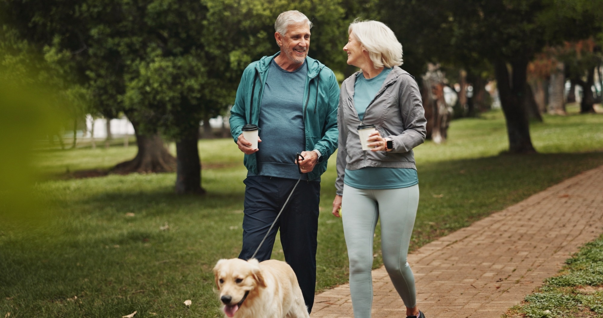 old couple and walking dog in park