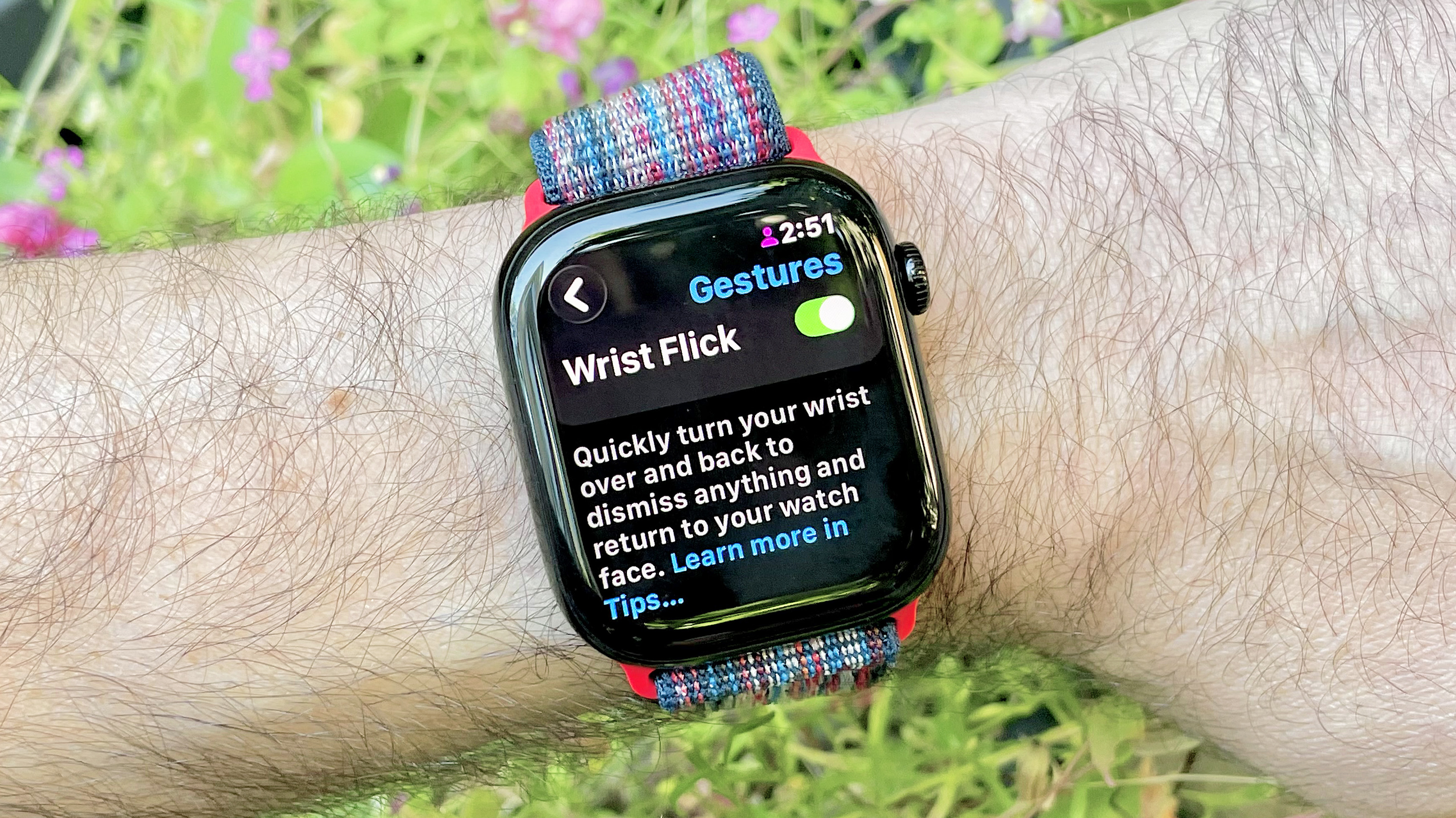 מקרוב של Apple Watch 10 בפרק כף היד של המשתמש המציג את אפשרות התפריט להפעיל את מחוות פליק שורש כף היד ב- WatchOS 26