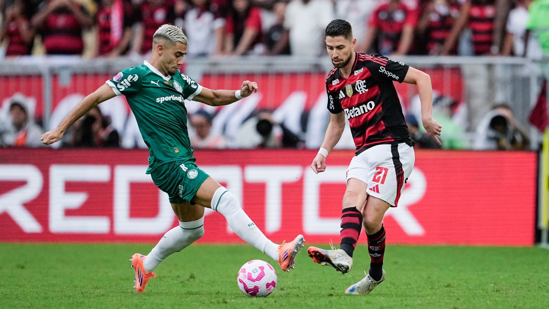 Flamengo's Jorginho passing the ball under pressure from Palmeiras' Andreas Pereira ahead of the 2025 Copa Libertadores final