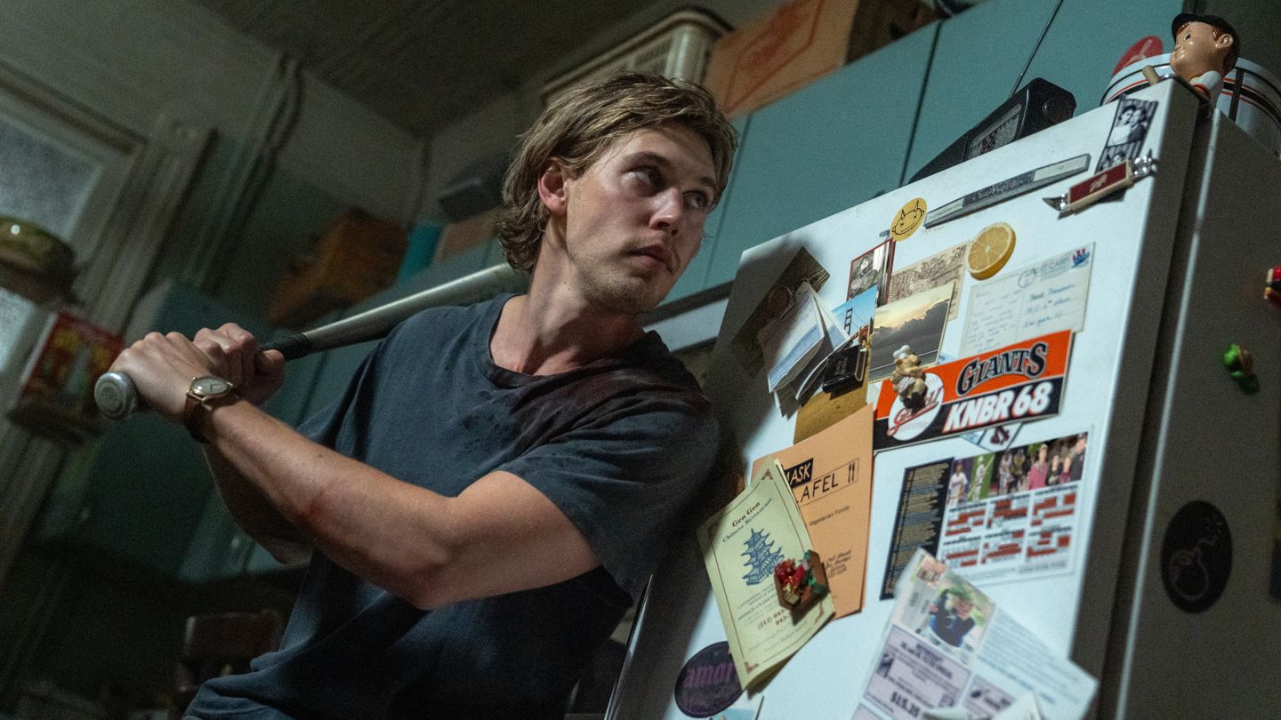 Hank (Austin Butler) readies a baseball bat in his kitchen inside his apartment in a scene from "Caught Stealing"