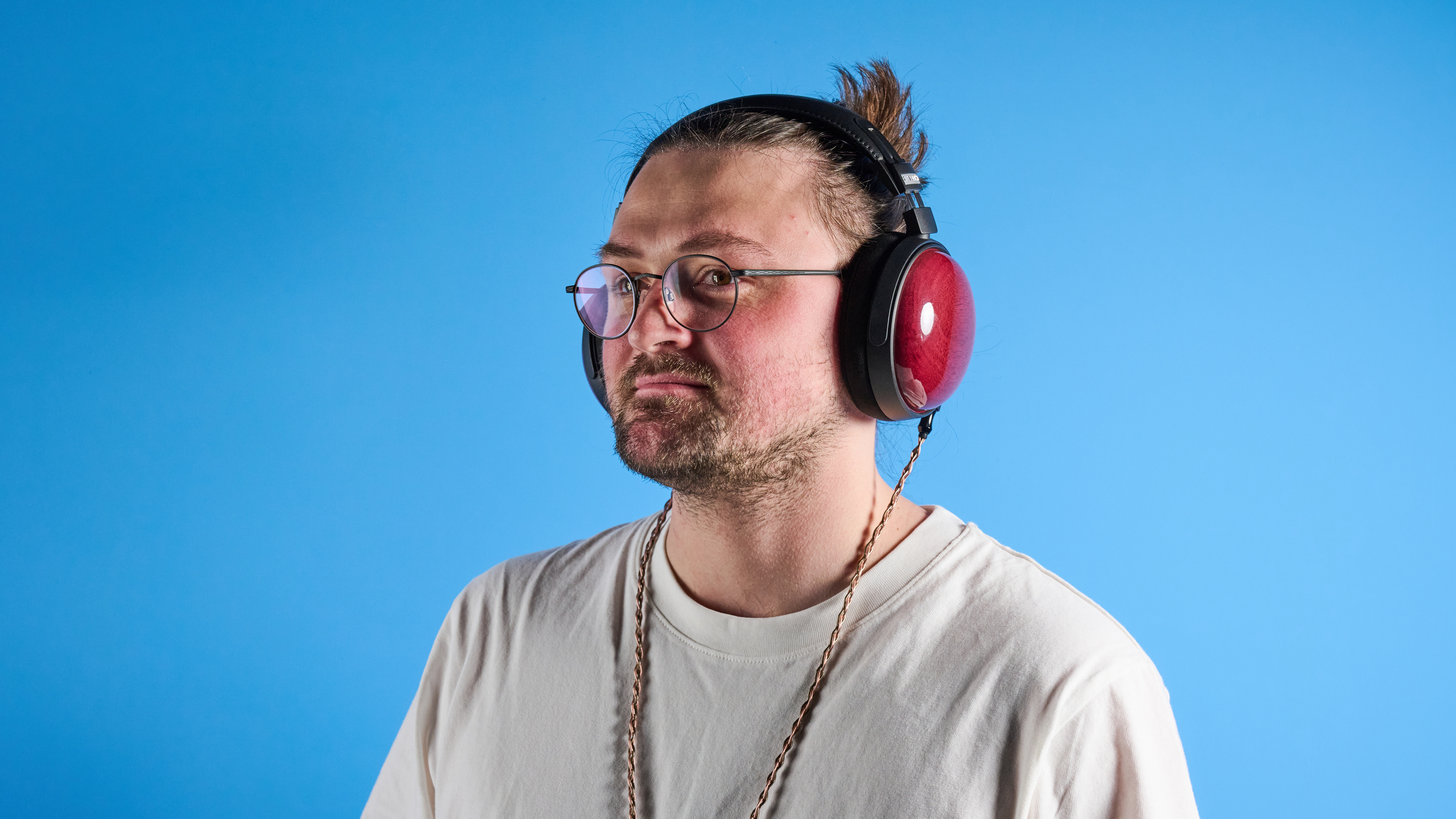 האוזניות החוטיות של fiio ft13 עם כוסות עץ וכבל נחושת שצולמו על רקע כחול