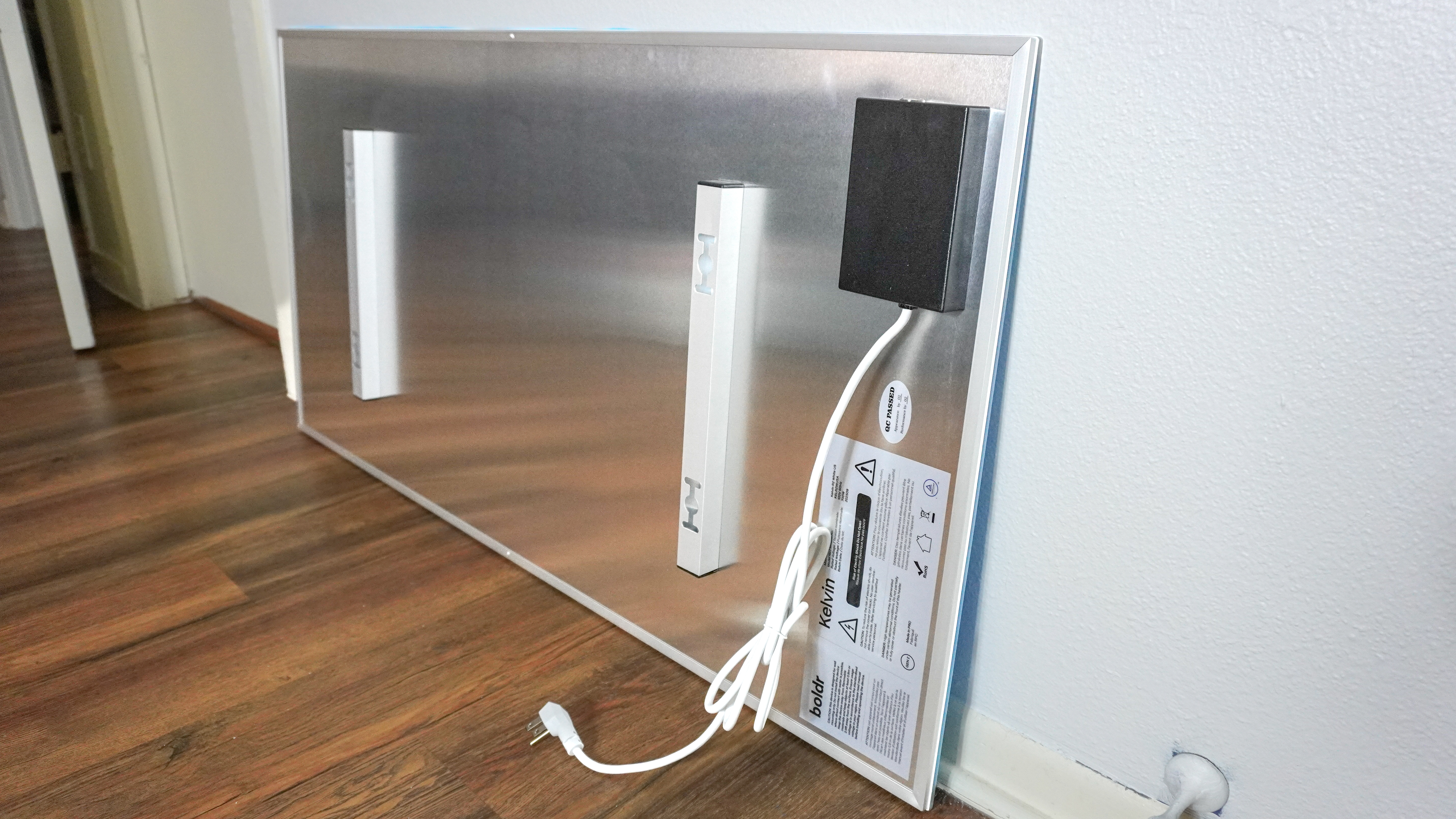 הצד האחורי של מחמם האינפרא אדום Boldr Kelvin מציג את חורי ההרכבה ומתאם החשמל שלו