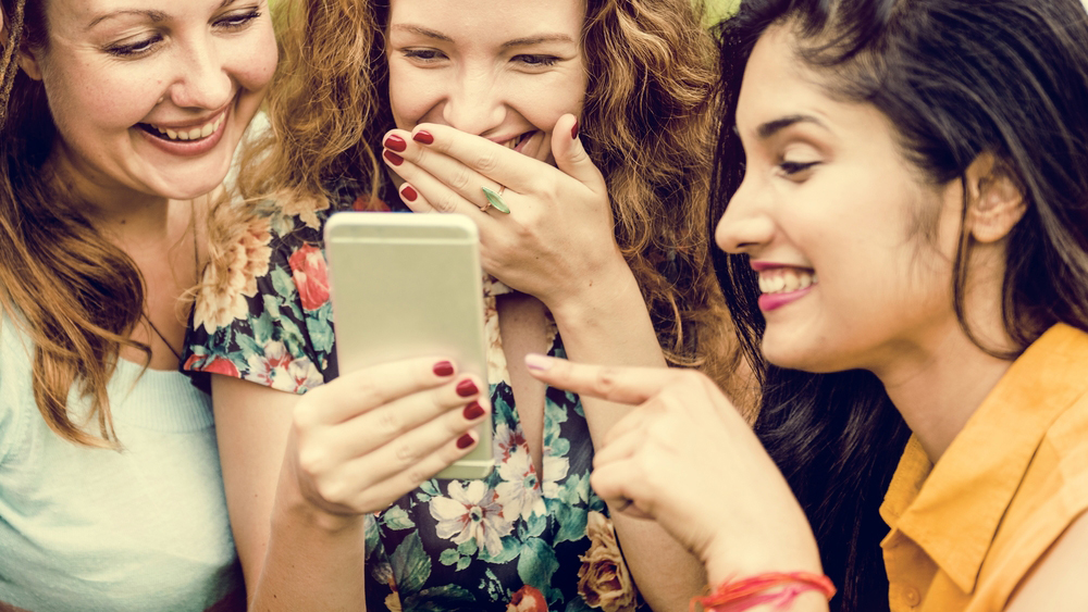 נשים צוחקות ממשהו בטלפון