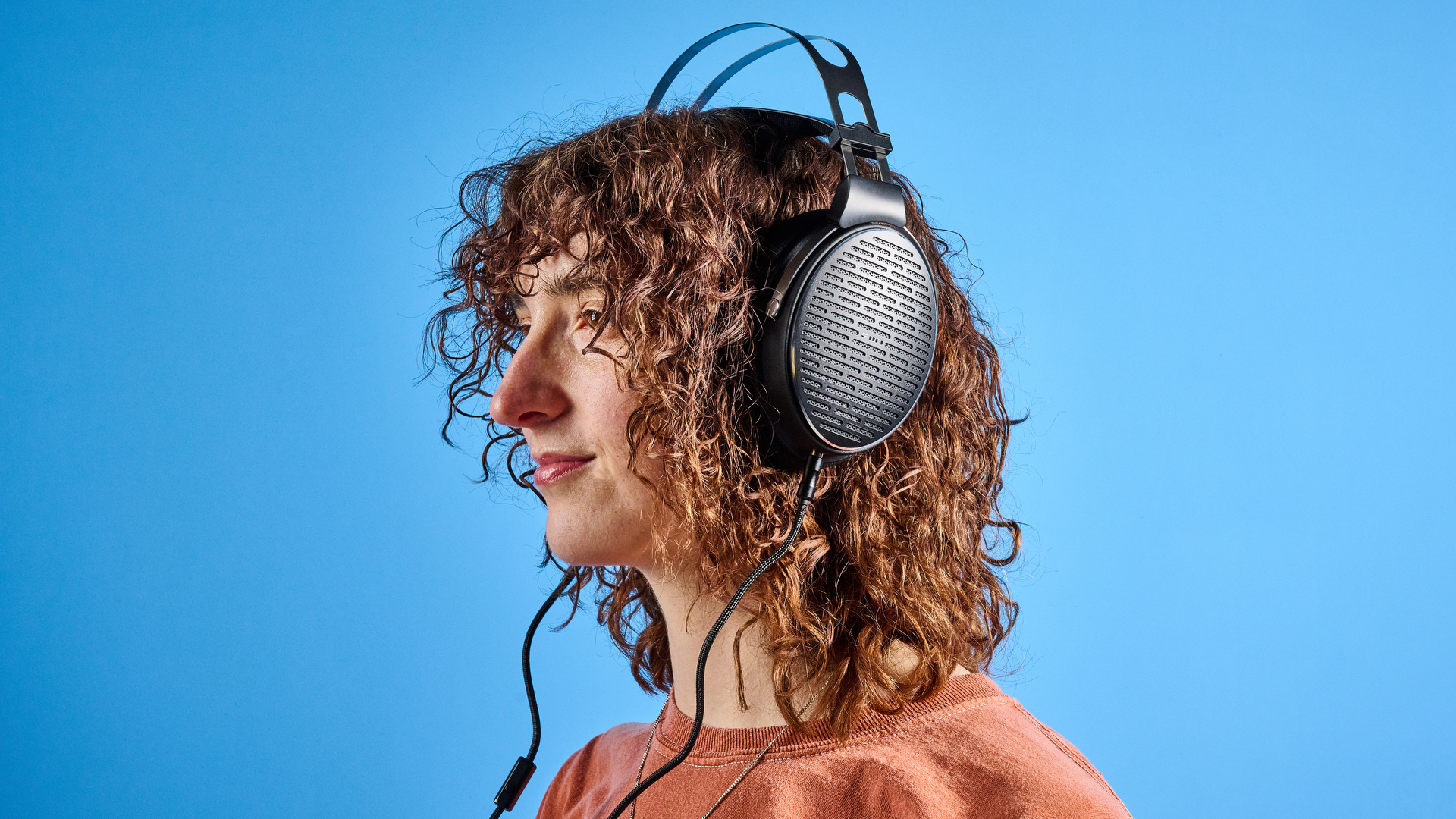 אוזניות ה-FiiO JT3 בשחור וכסף המוצגות על רקע המדריך הכחול של Tom's