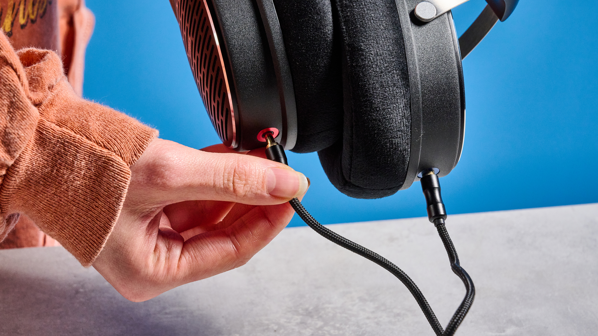 אוזניות ה-FiiO JT3 בשחור וכסף המוצגות על רקע המדריך הכחול של Tom's